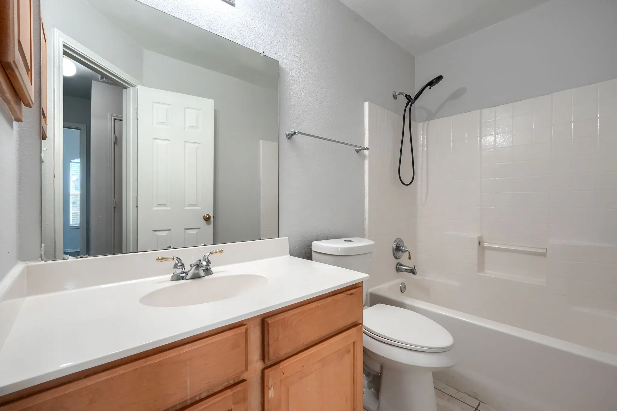 Wood-finish vanity with a white countertop and an integrated sink