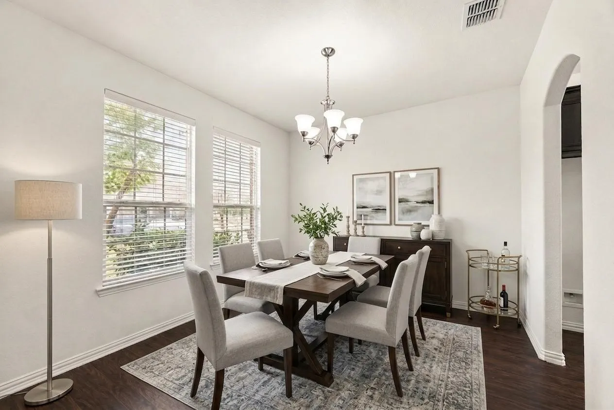 Recessed lighting, wood-finish flooring, white walls, two large windows with blinds, and an arched doorway