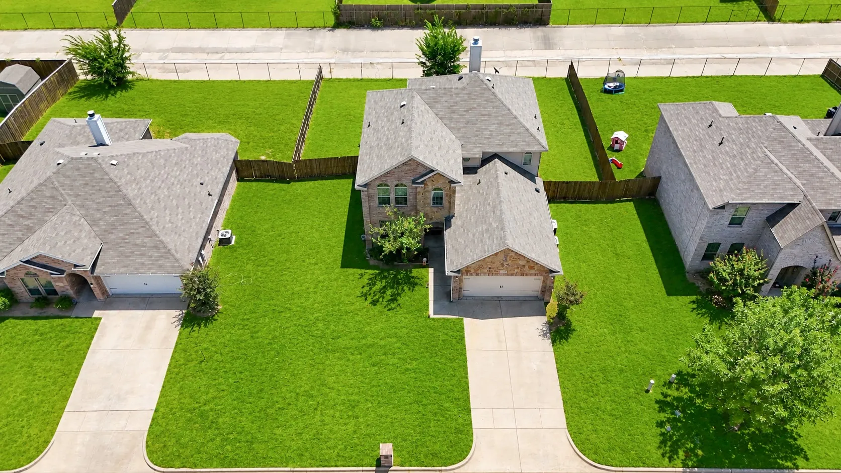 Single-family residence featuring a brick and stone exterior, an attached two-car garage, and a concrete driveway