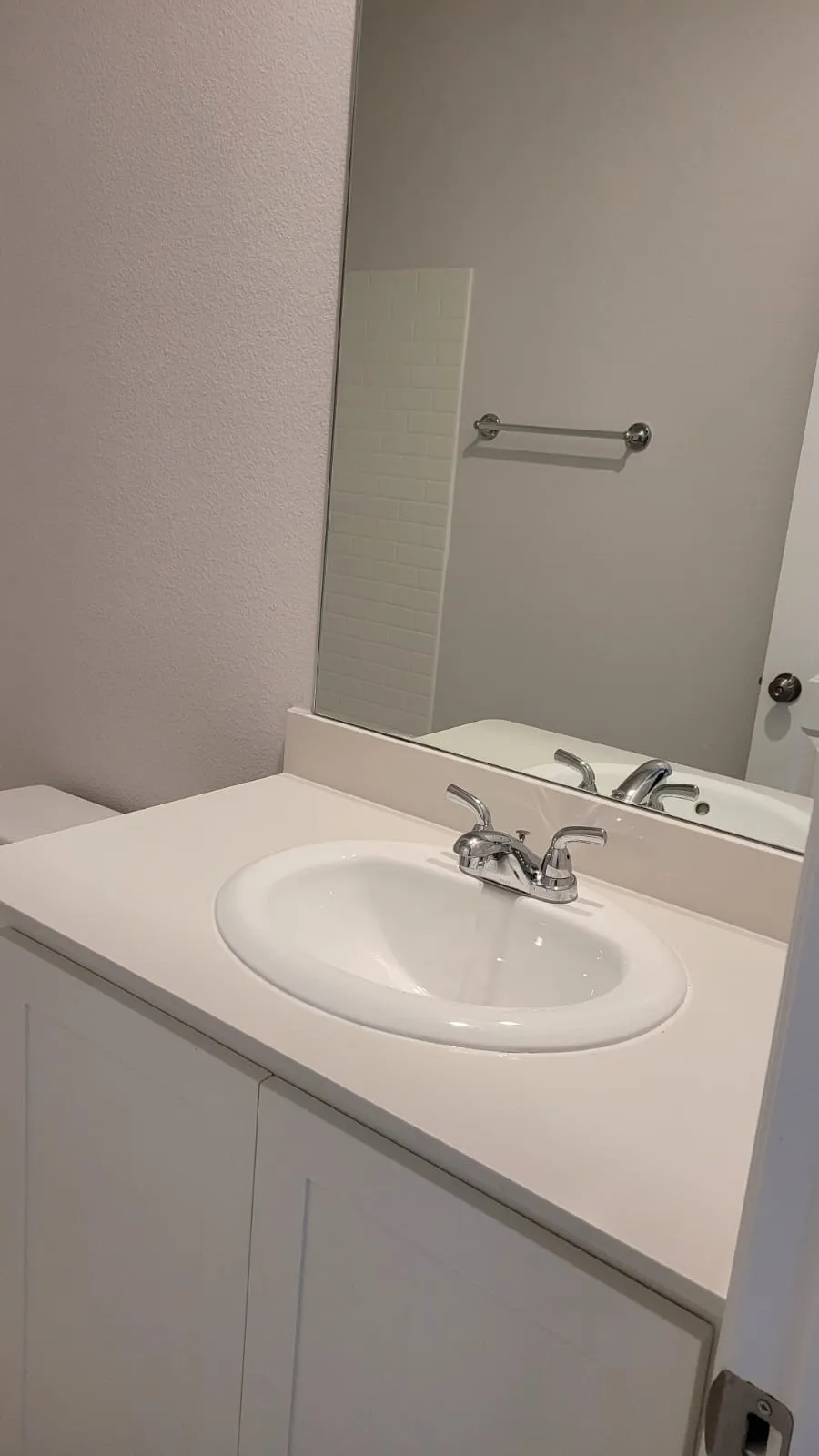White vanity with an integrated oval sink and chrome faucet