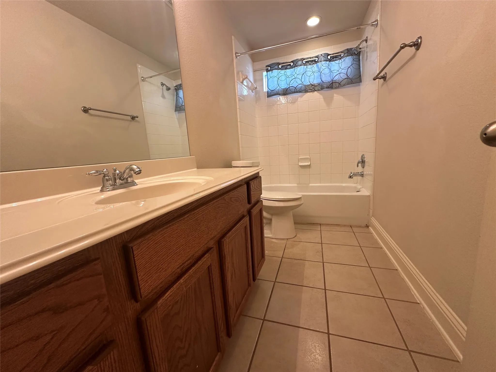 Bathroom with a single vanity, integrated sink, and wood-finish cabinetry
