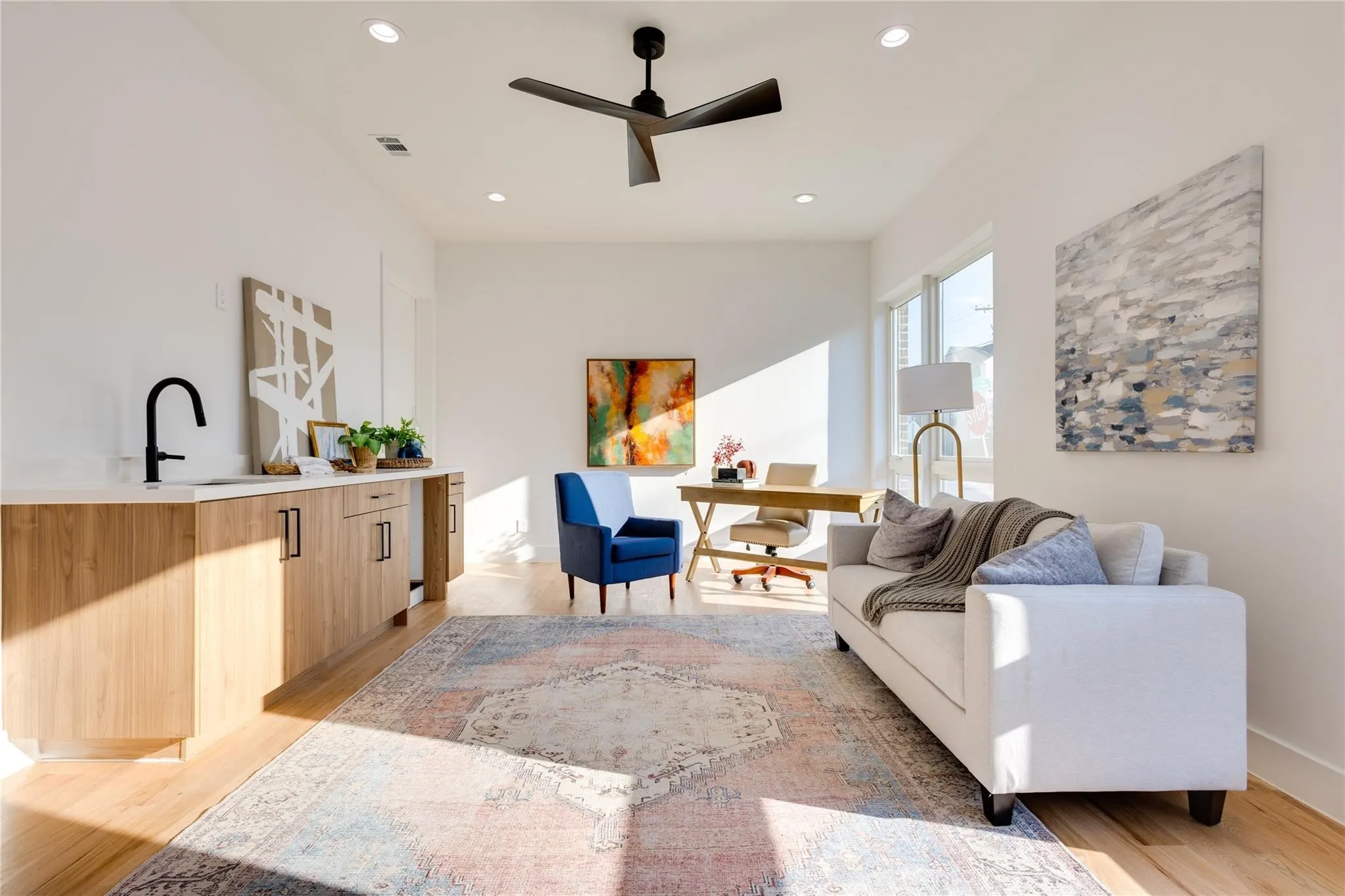 Living room featuring sink, light hardwood / wood-style floors, and ceiling fan