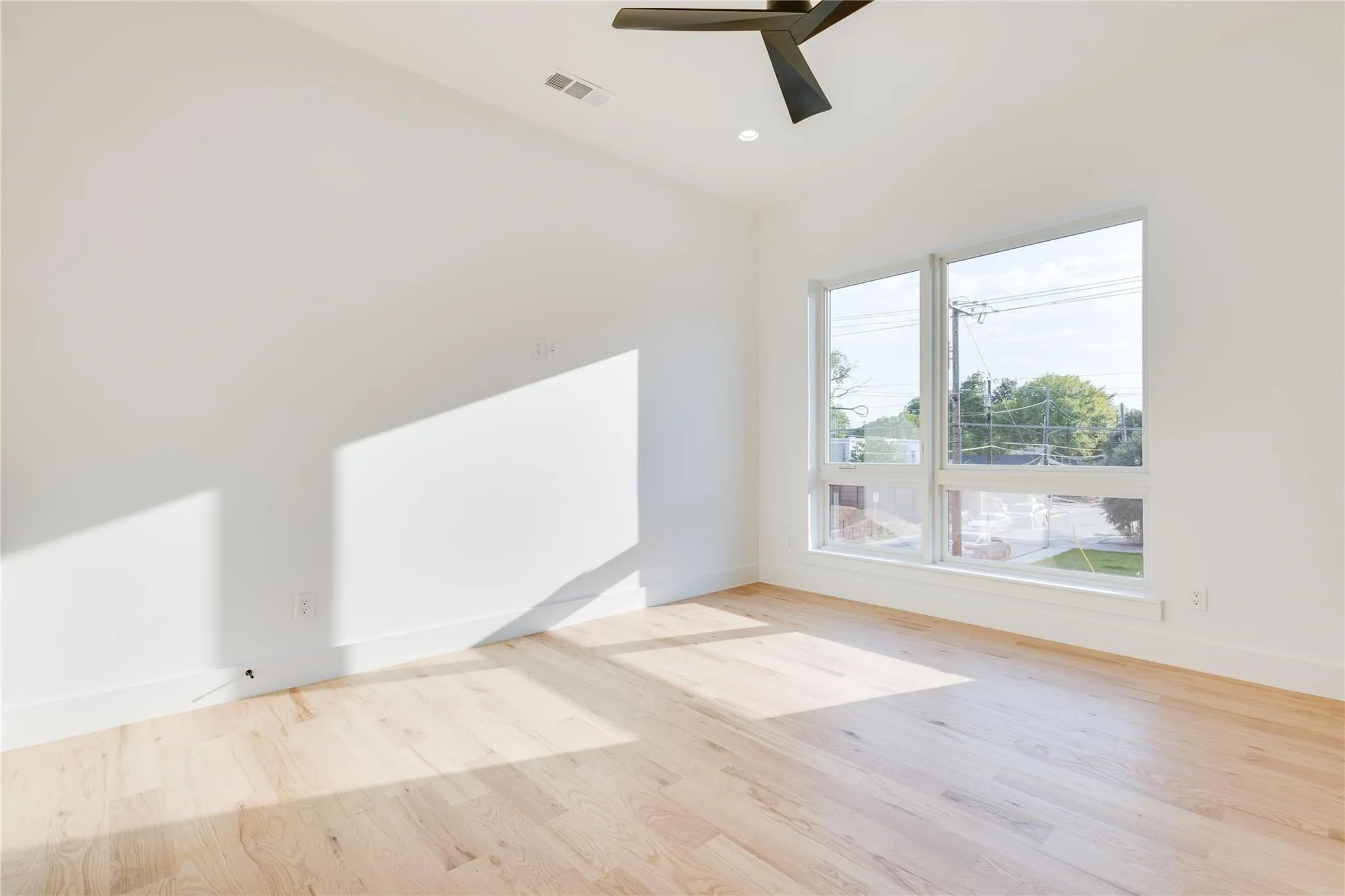 Unfurnished room featuring ceiling fan and light wood-type flooring