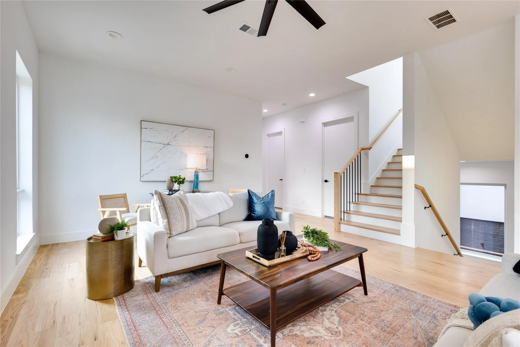 Living room with ceiling fan and light hardwood / wood-style flooring