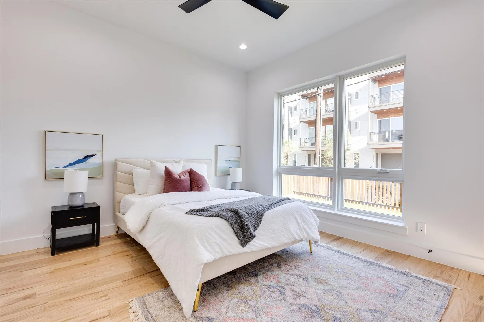 Bedroom with multiple windows, ceiling fan, and light hardwood / wood-style floors
