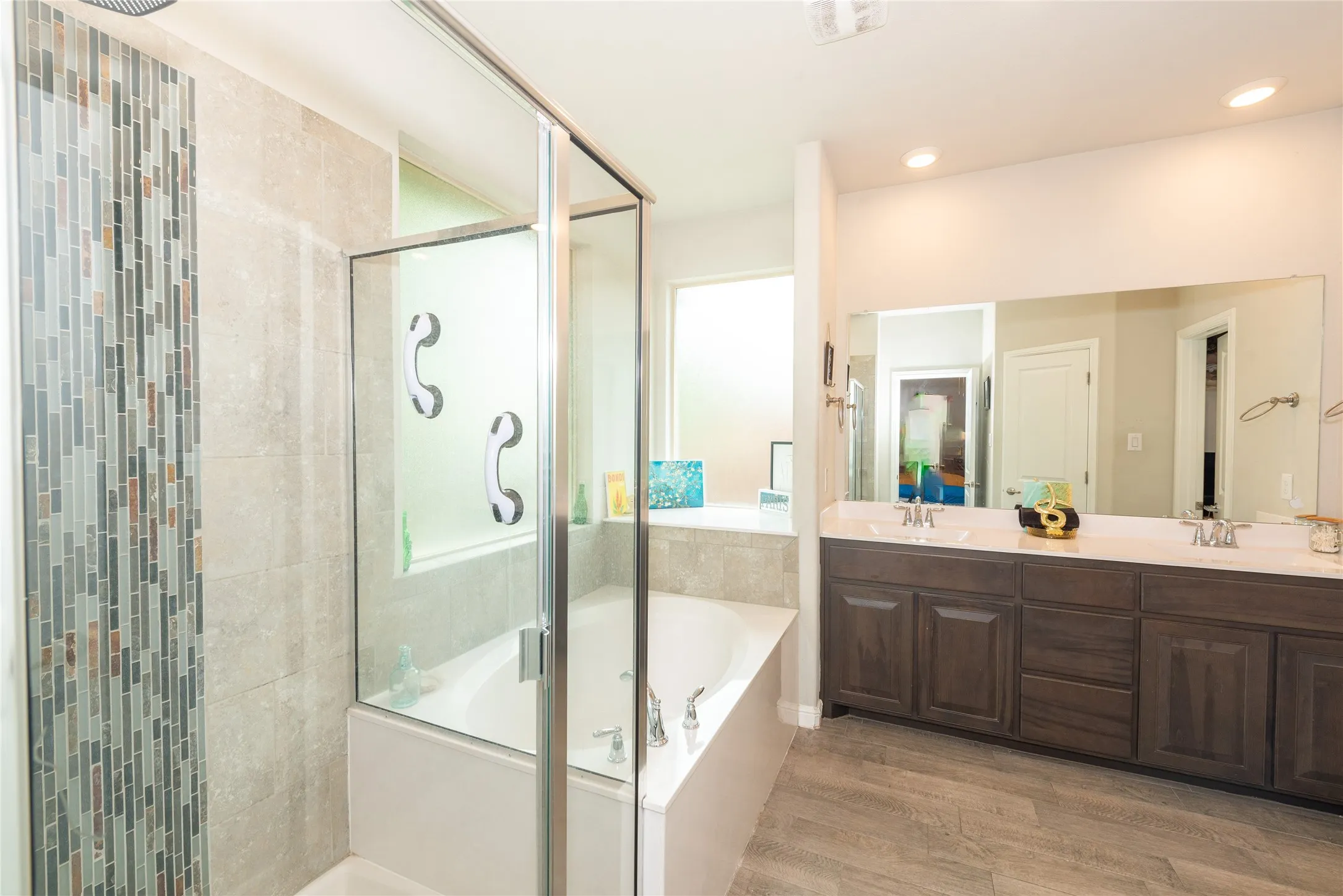 Walk-in shower with glass enclosure and mosaic tile accent