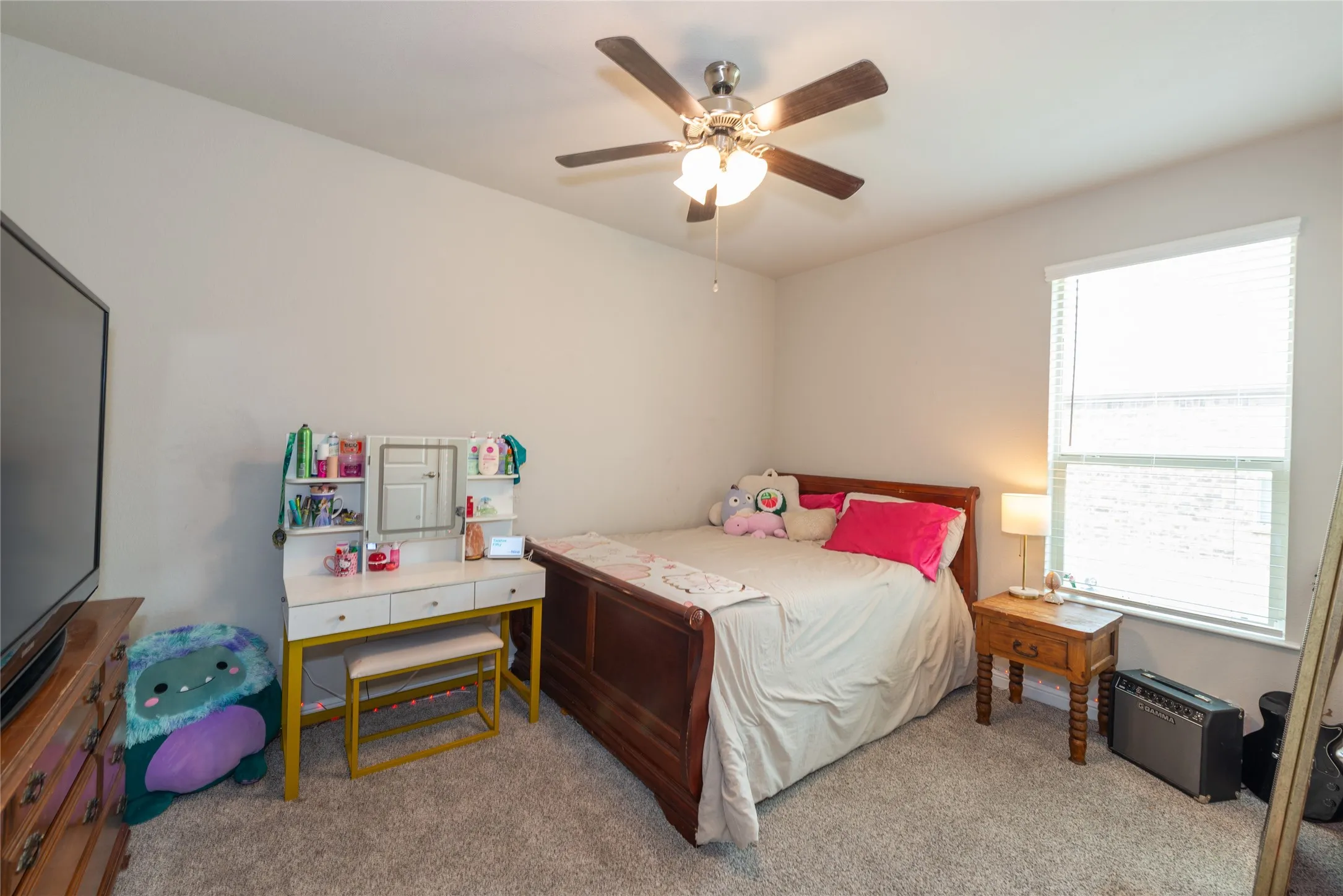 Recessed window with blinds, ceiling fan with integrated lighting, and carpeted flooring