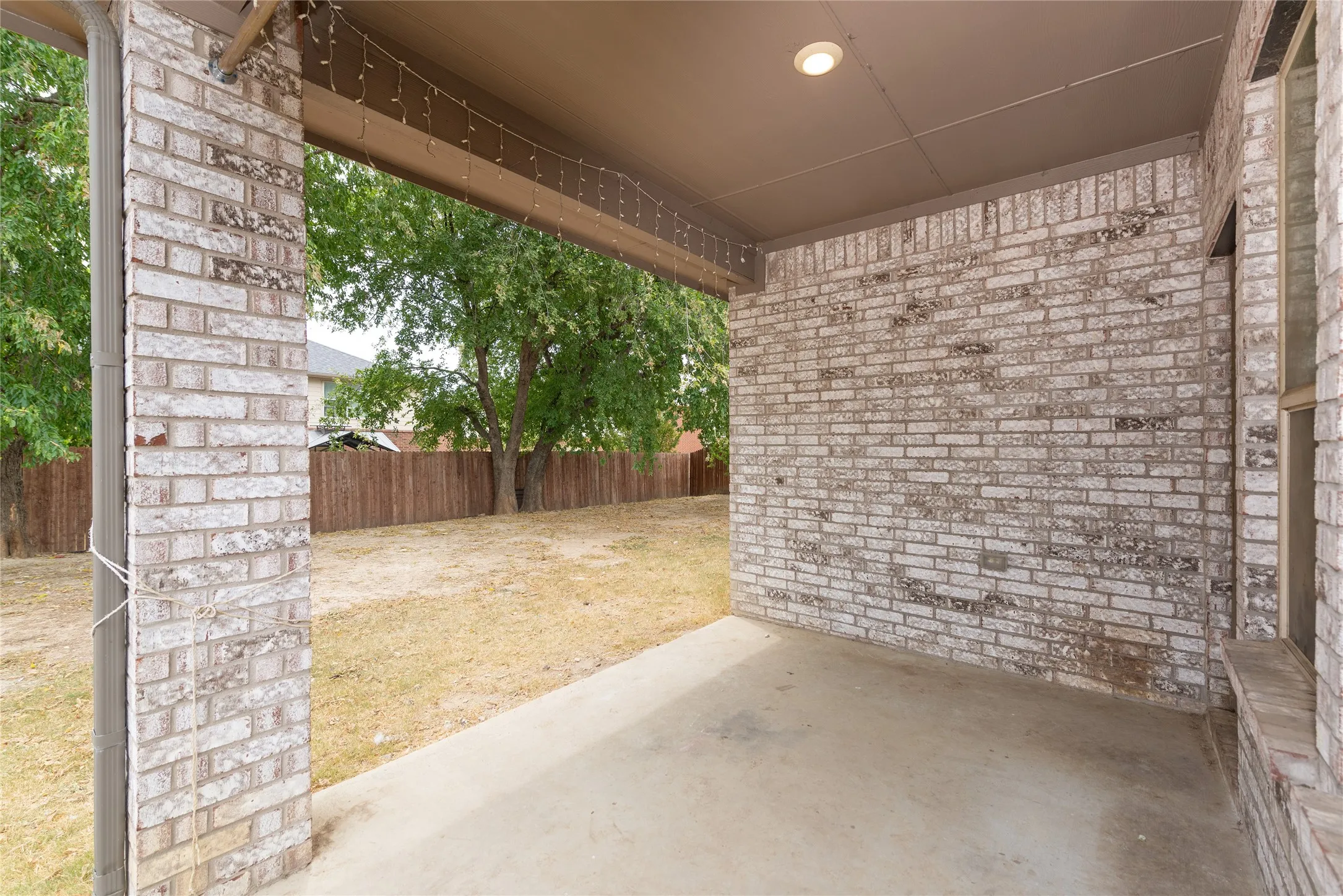 Covered patio with a concrete floor, recessed lighting, and brick columns