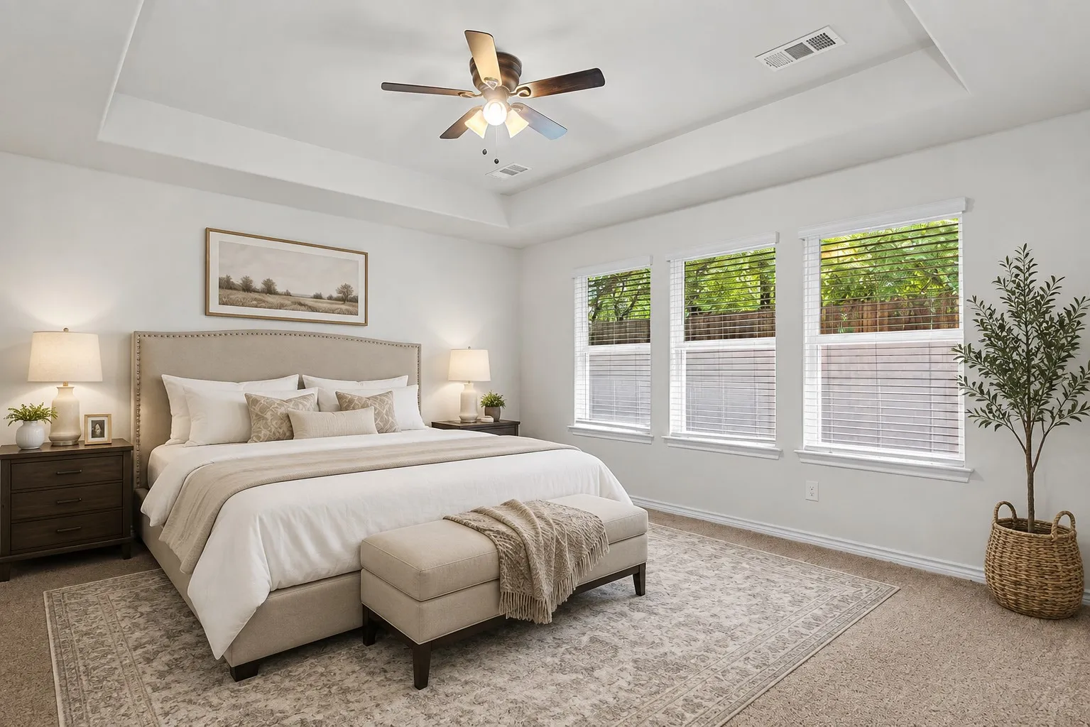 Tray ceiling with a ceiling fan, three windows with white blinds, and carpeted flooring