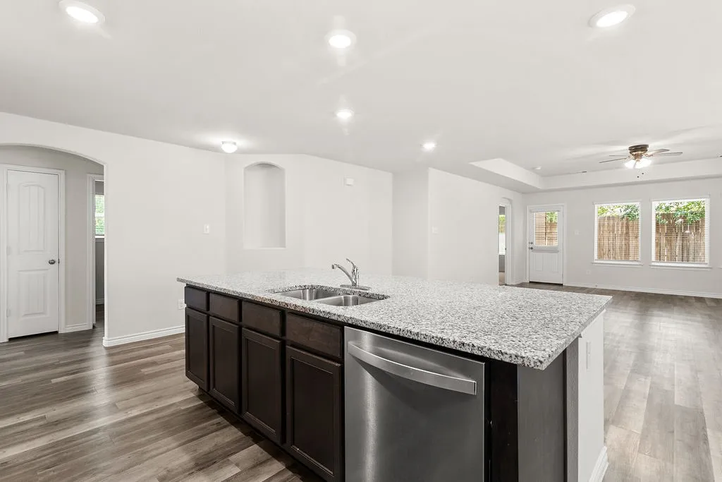 Kitchen island with integrated stainless steel dishwasher, dual basin sink, and granite countertop