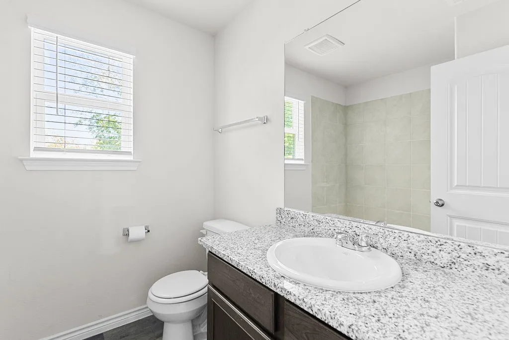 Vanity with a light-toned countertop, integrated sink, and dark wood-finish cabinetry