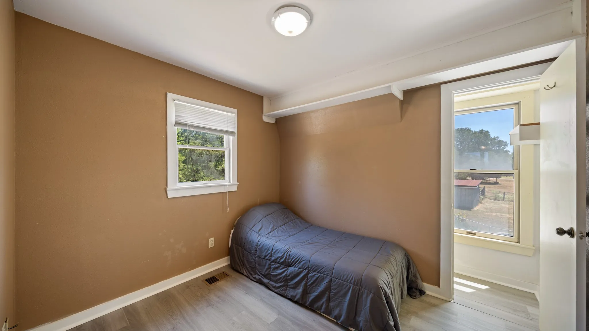 Wood-finish flooring with neutral wall paint and white trim