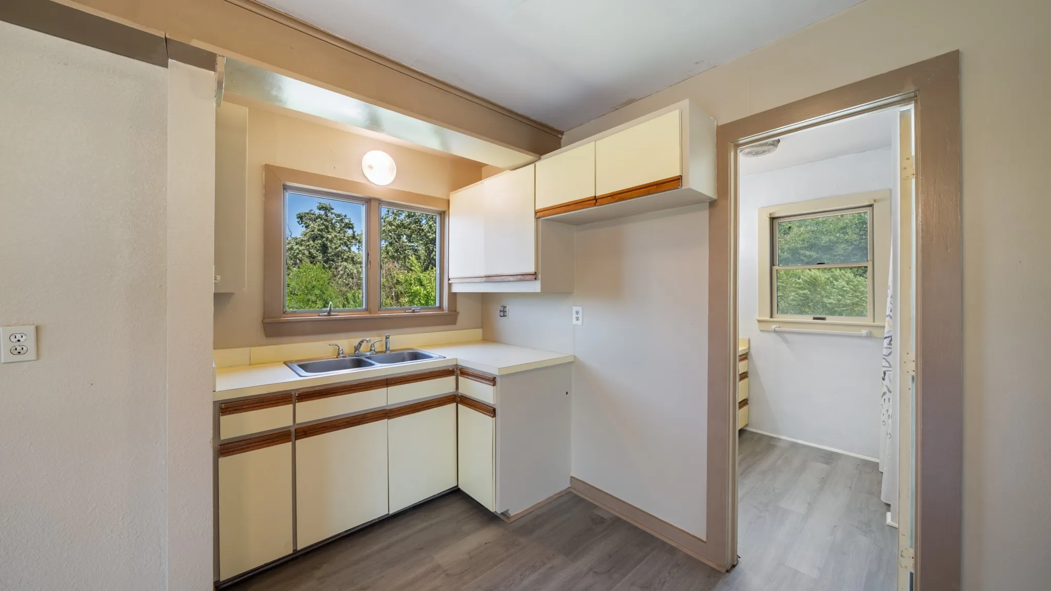 Kitchenette featuring a double basin sink, ample countertop space, and wood-finish flooring