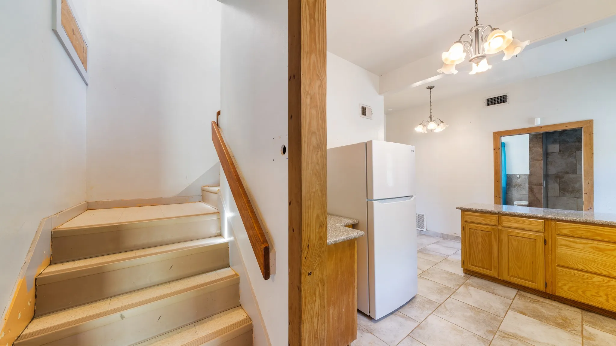 Staircase with wood handrail, tile flooring, wood cabinetry, and recessed lighting
