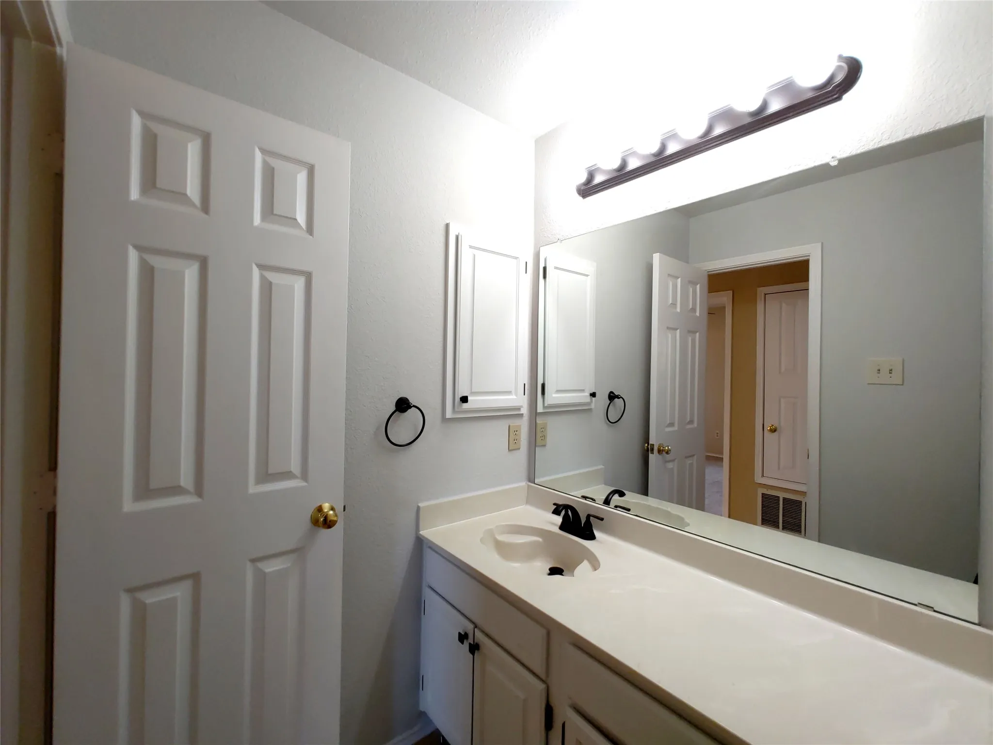 Vanity with an integrated sink, black faucet, and white cabinetry