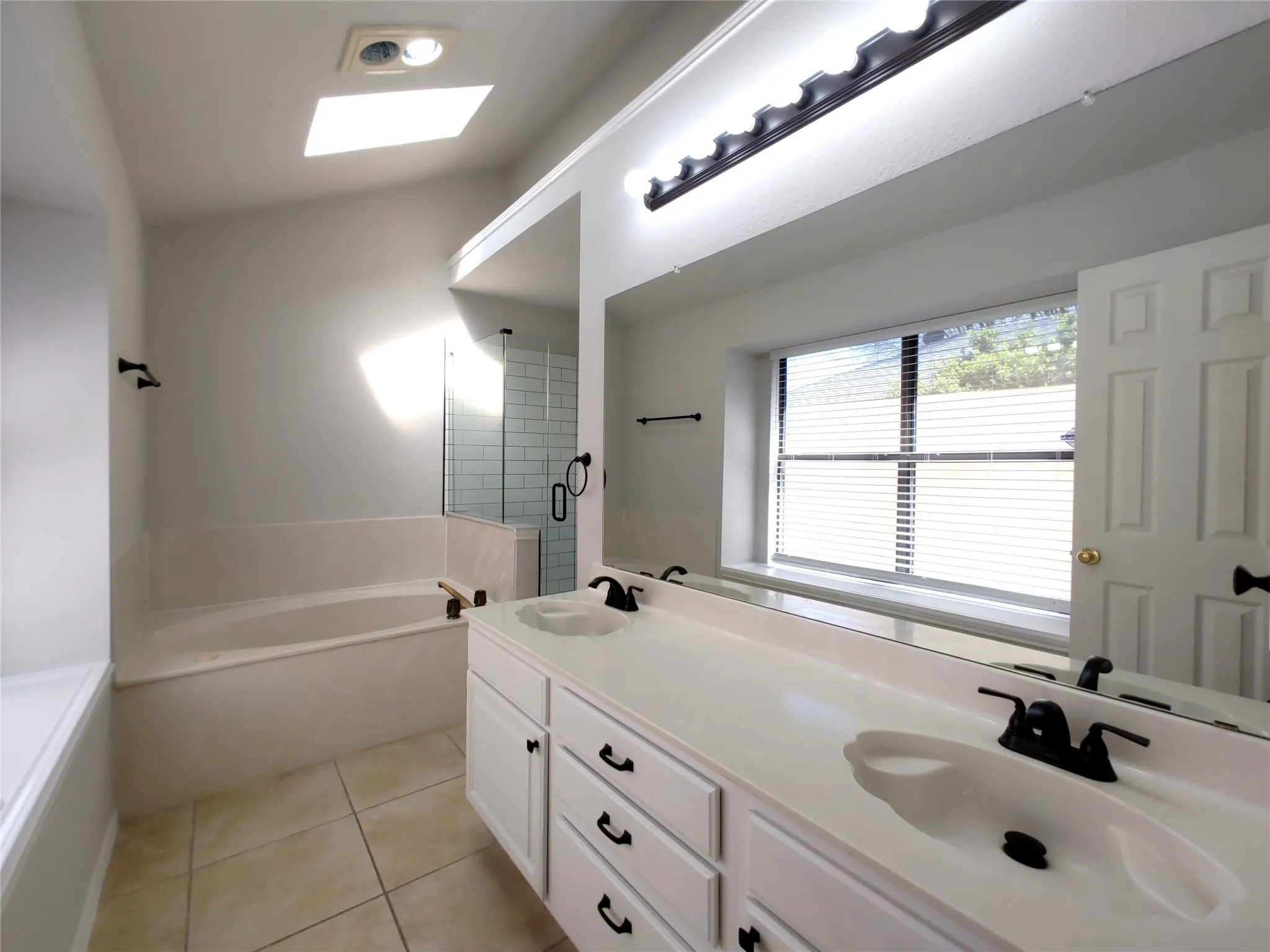 Dual vanity with integrated sinks, full-width mirror, and matte black fixtures