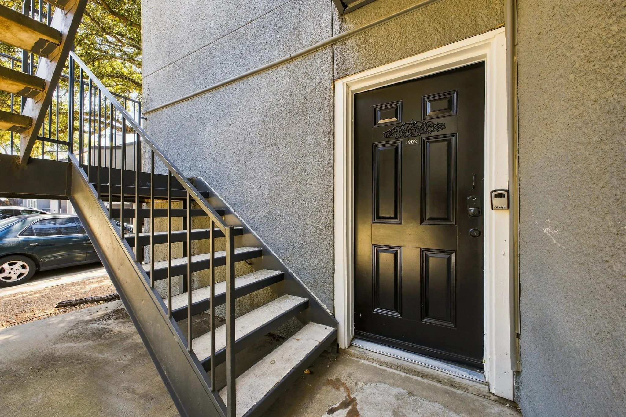 Black paneled entry door with decorative trim and white frame