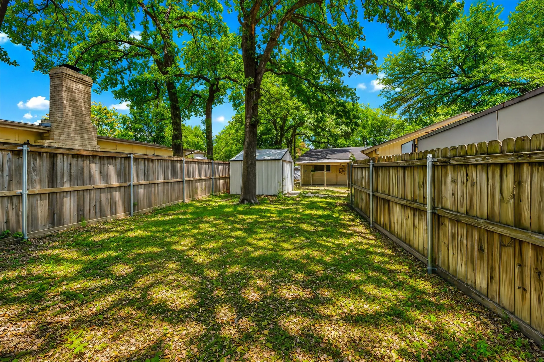 From the southern fence line looking north toward the house with a storage shed to the left.