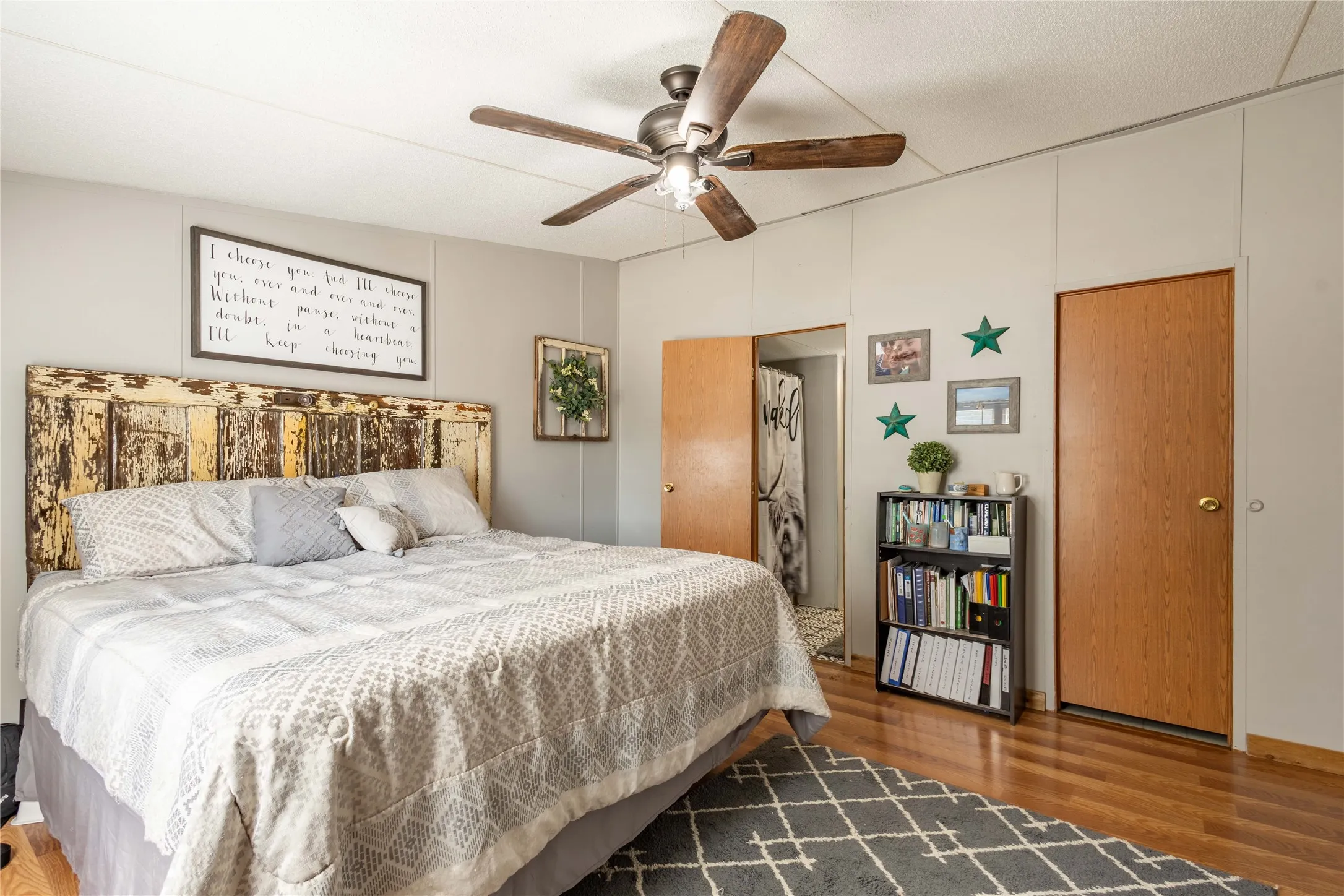 Wood-finish flooring, ceiling fan, and light-toned walls