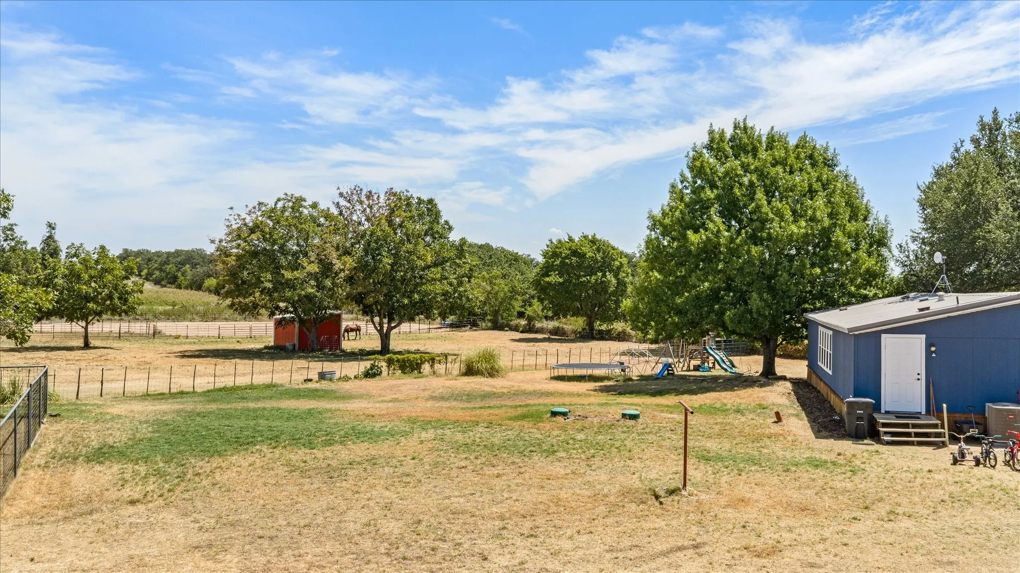 Backyard looking over horse pastures with mature trees