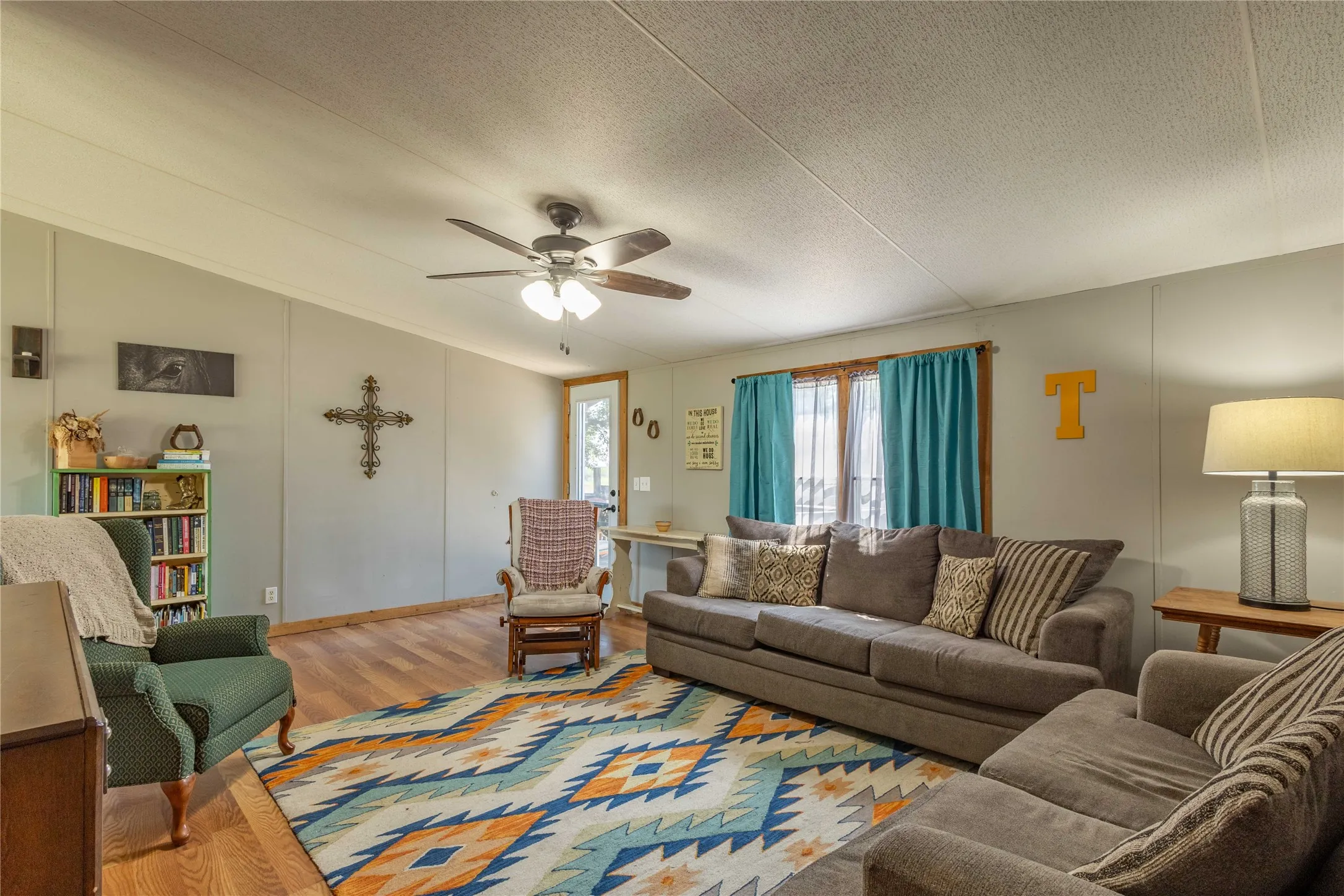 Wood-finish flooring with light gray walls and a ceiling fan with integrated lighting