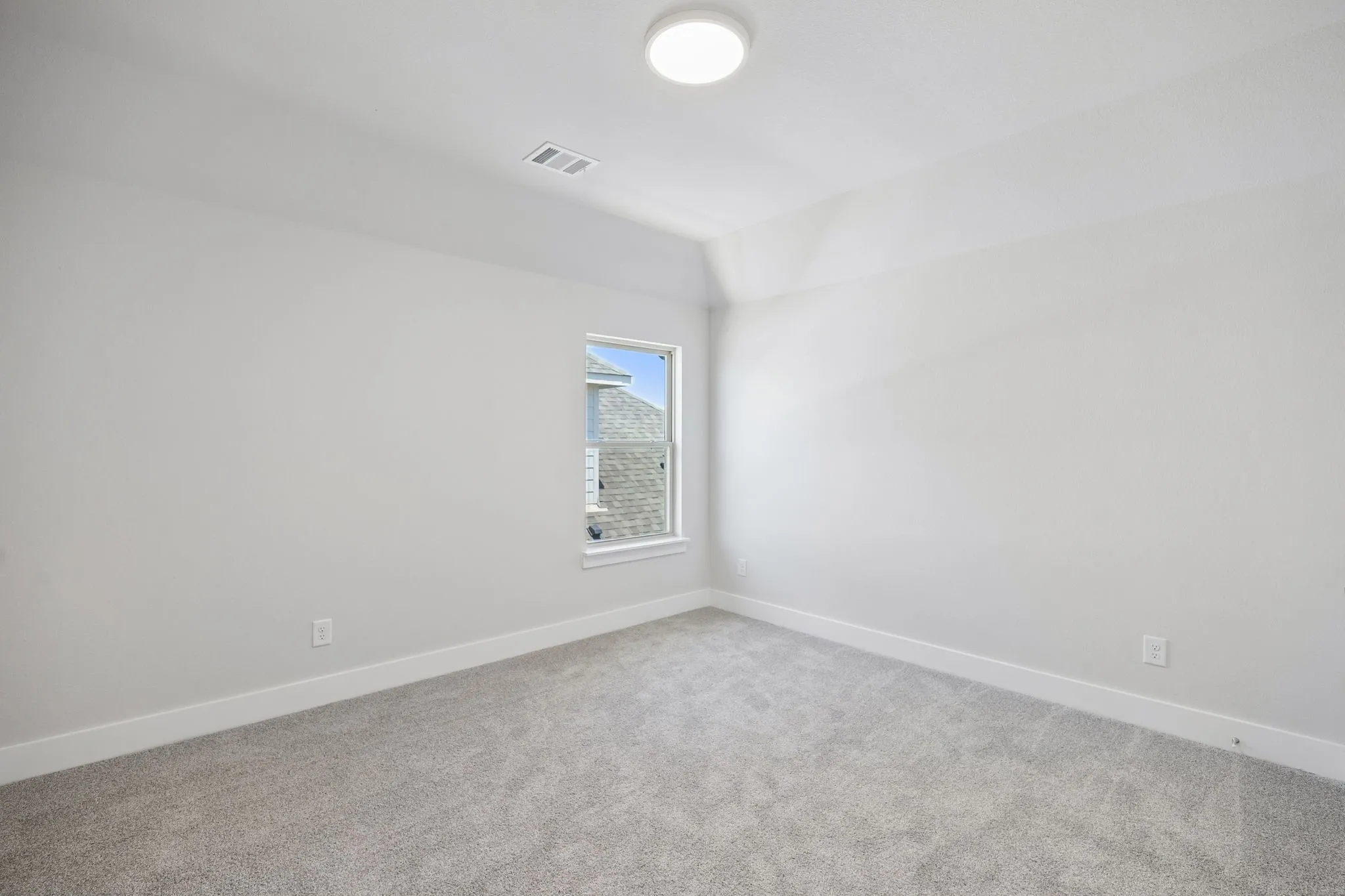 Bright corner bedroom with neutral wall finishes, recessed ceiling lighting, and soft carpet flooring