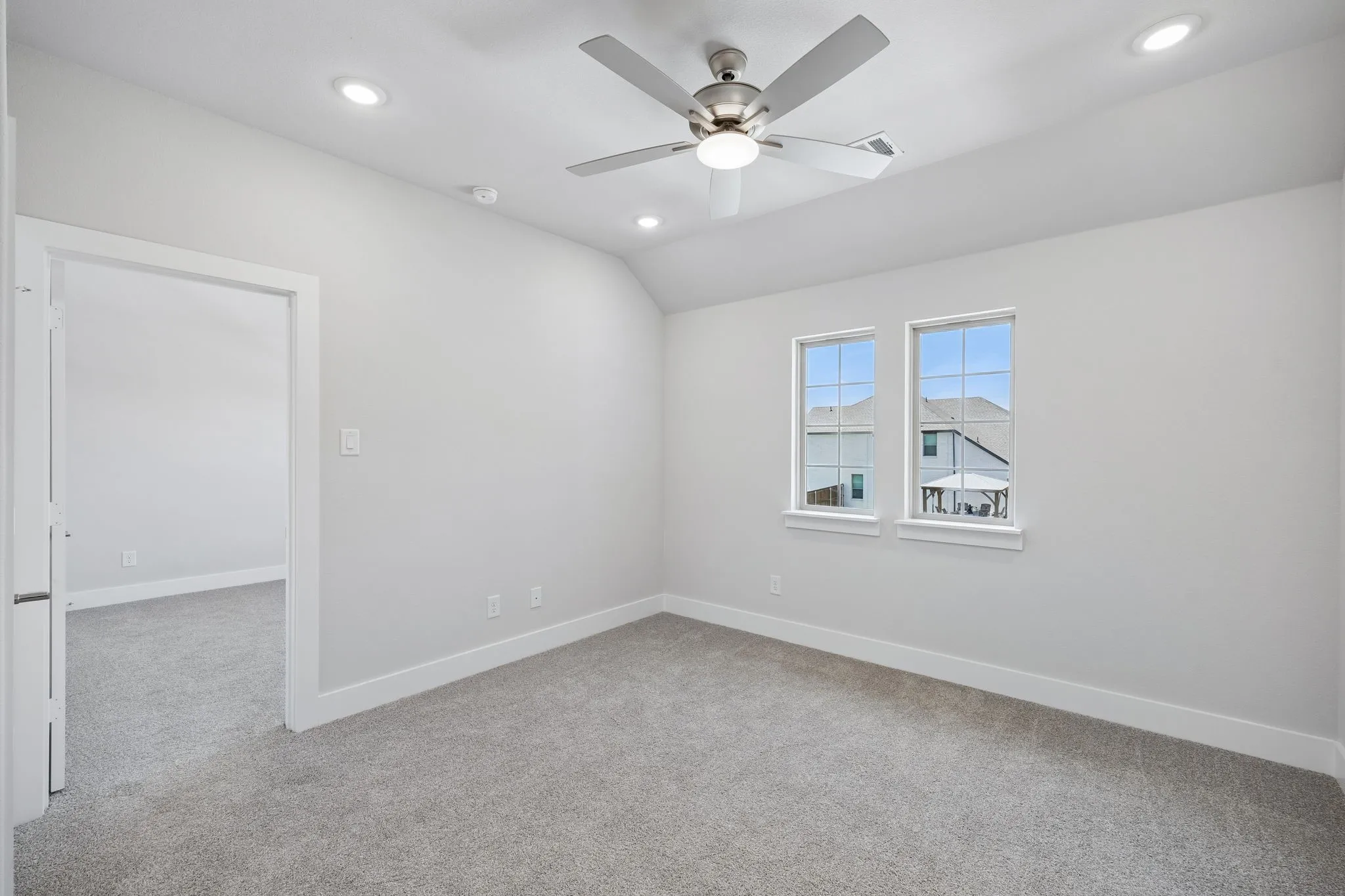 Recessed lighting, ceiling fan, and light gray carpeting