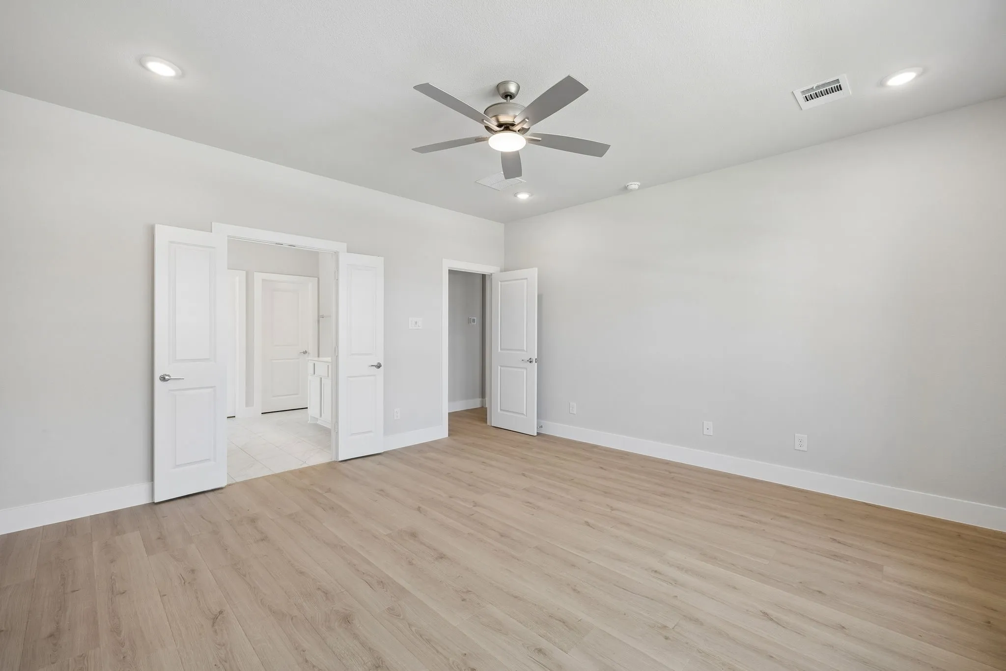 Light wood-finish flooring, recessed lighting, and a ceiling fan with integrated lighting