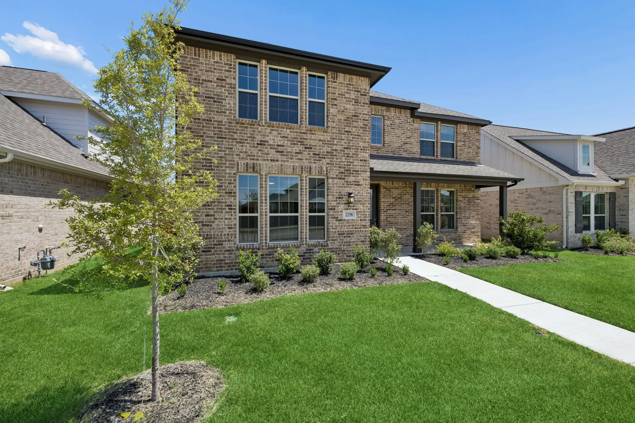 Brick-clad exterior with dark trim and multiple windows