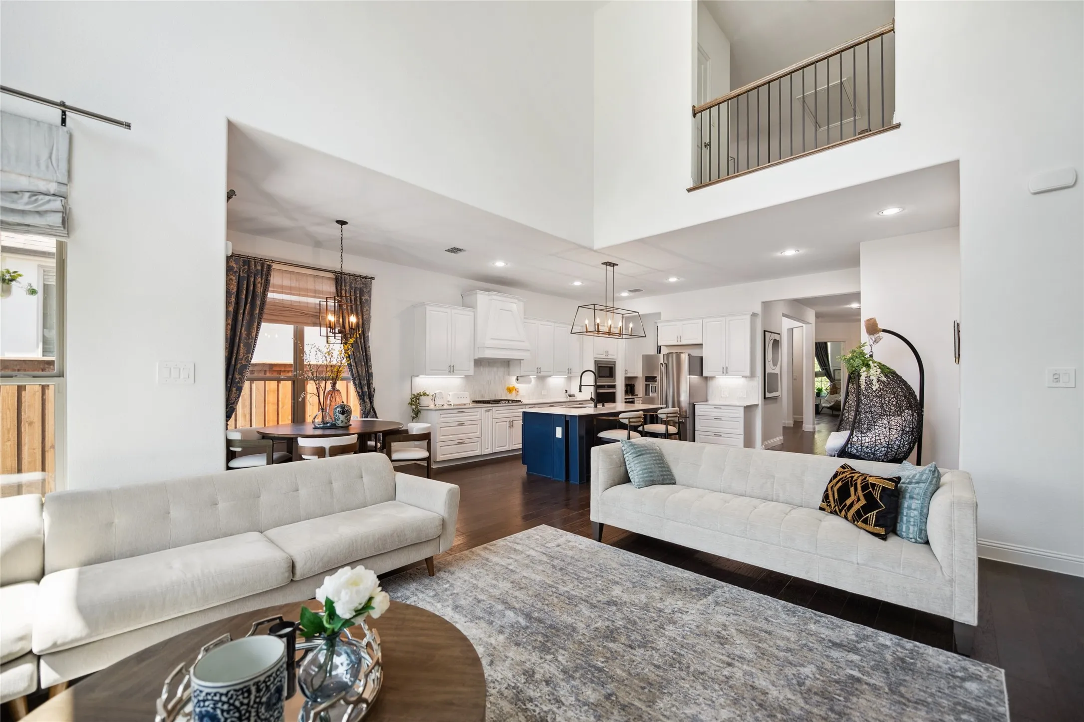 Soaring ceilings with a second-story landing featuring metal railings