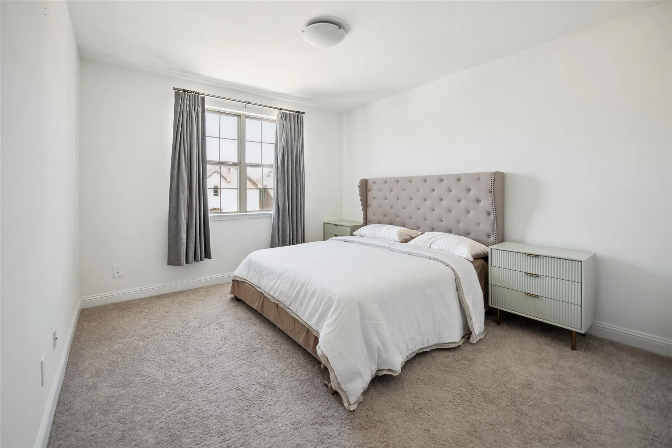 Spacious room featuring neutral carpeting, a large window, and crown molding