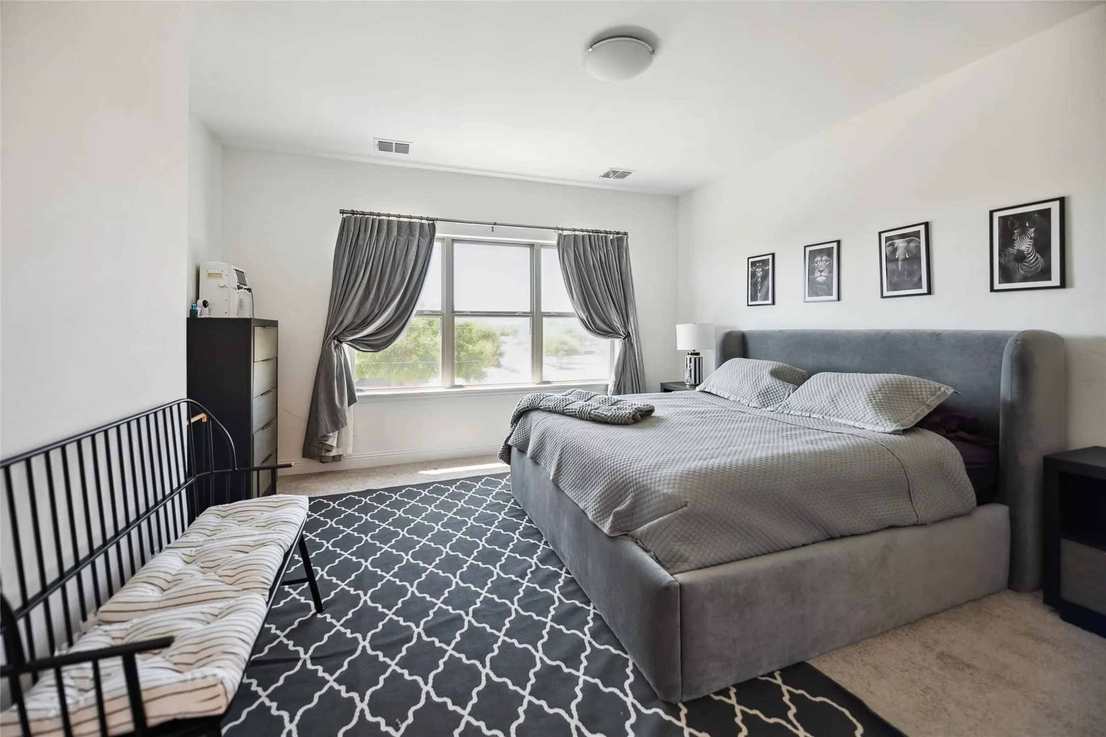 Recessed lighting, window with drapes, wall-mounted light fixture, and neutral carpeting