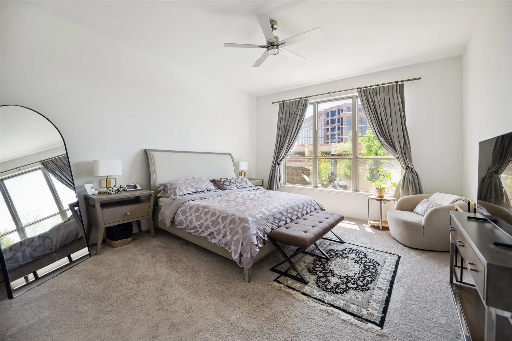 Recessed lighting, ceiling fan, large windows with drapes, and plush carpet flooring