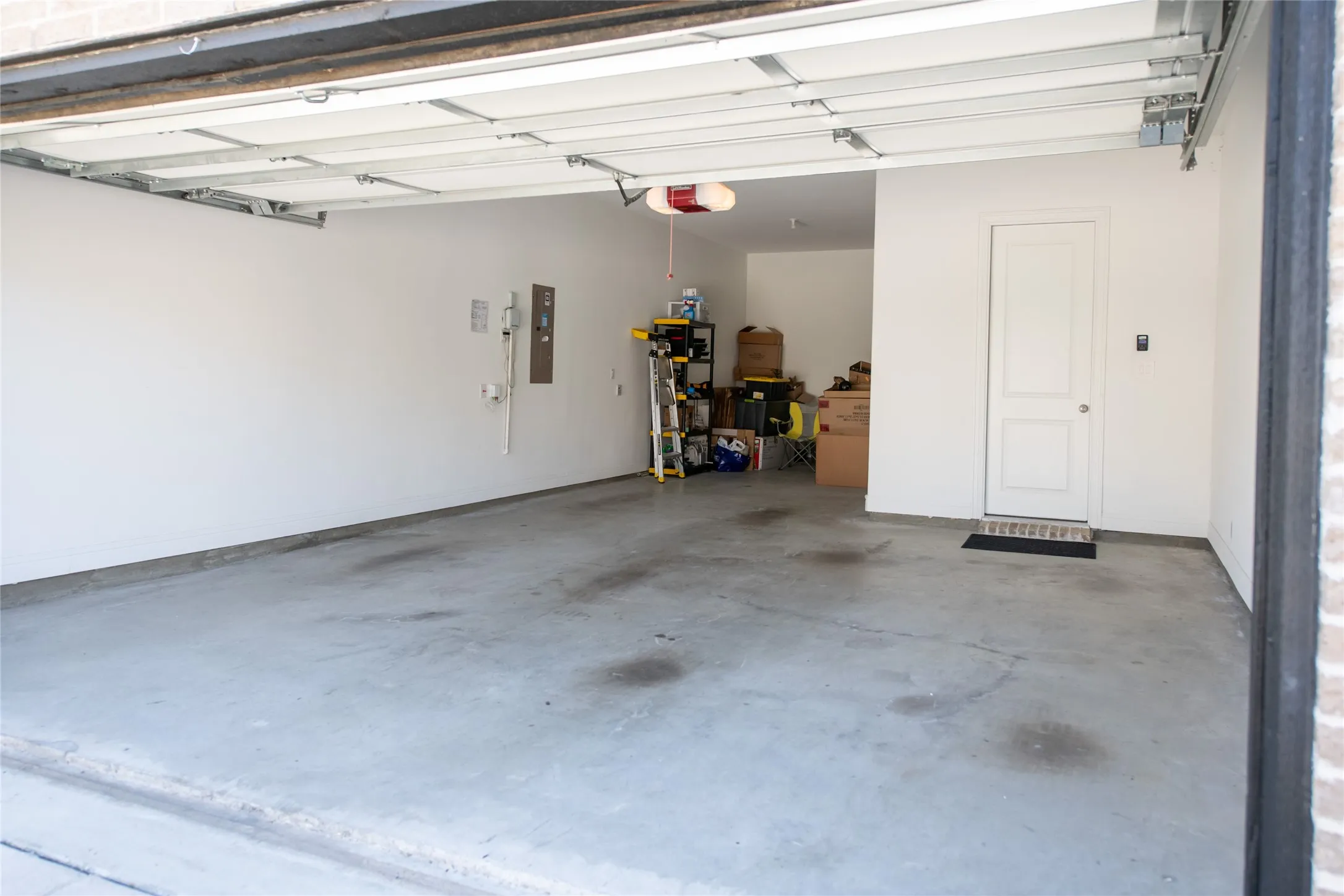 Attached garage featuring concrete flooring and a white paneled door