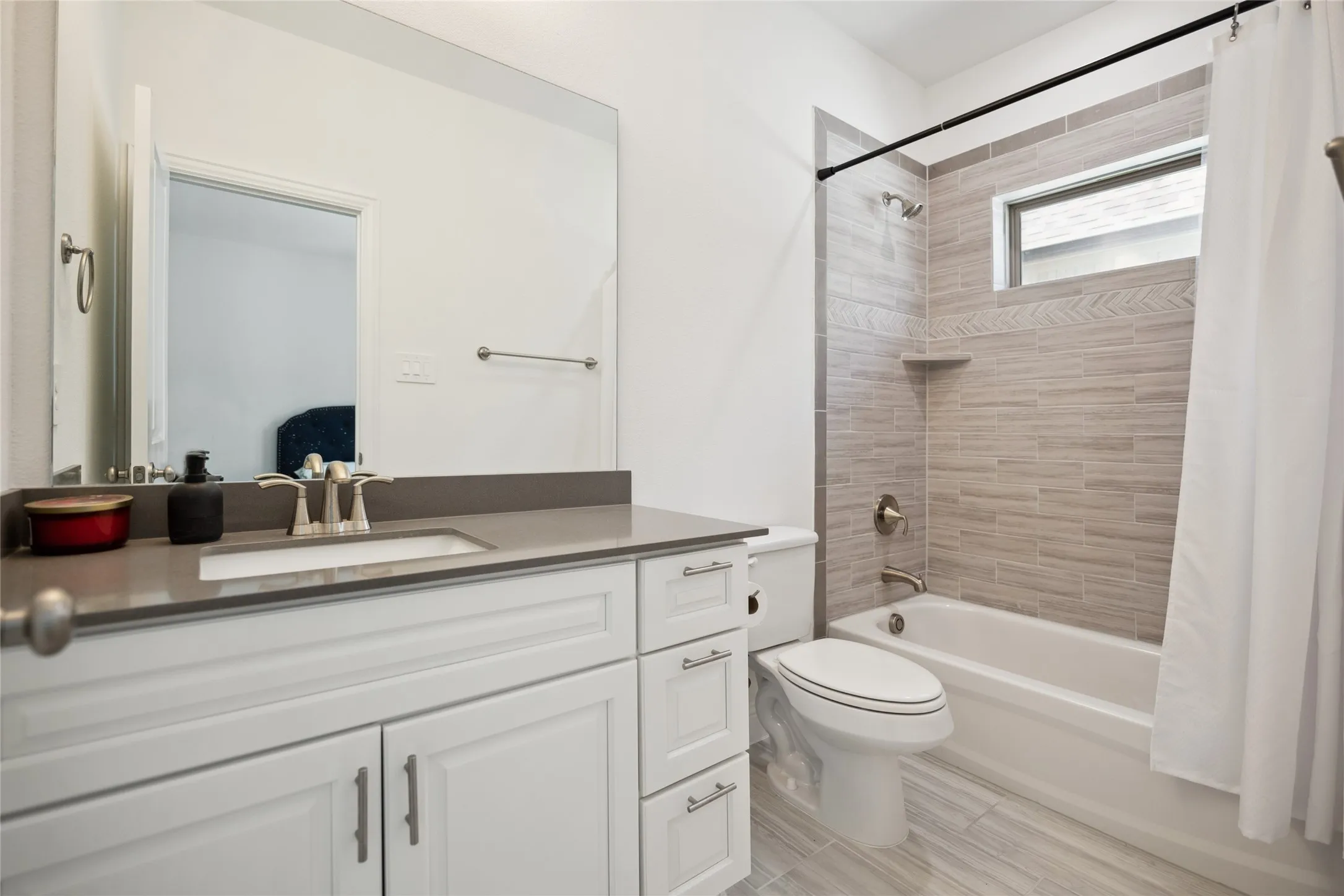 White vanity with integrated sink, matte gray countertop, and brushed nickel fixtures
