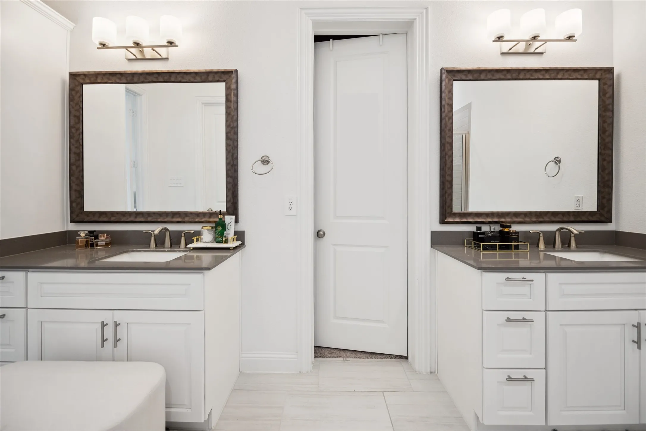 Dual vanity featuring white shaker cabinetry, undermount sinks, and grey countertops