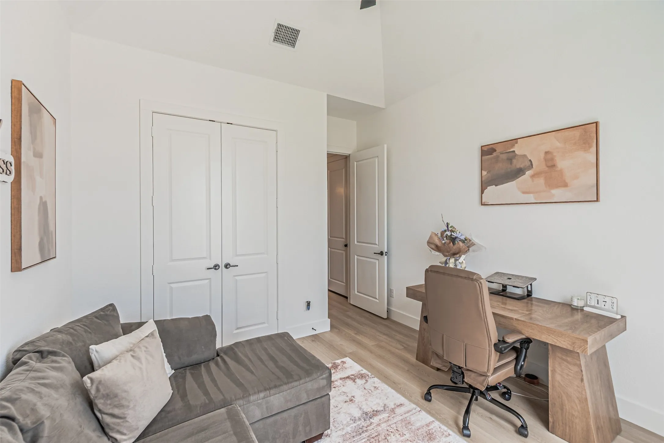 Vaulted ceiling, wood-finish flooring, white walls, and white paneled doors