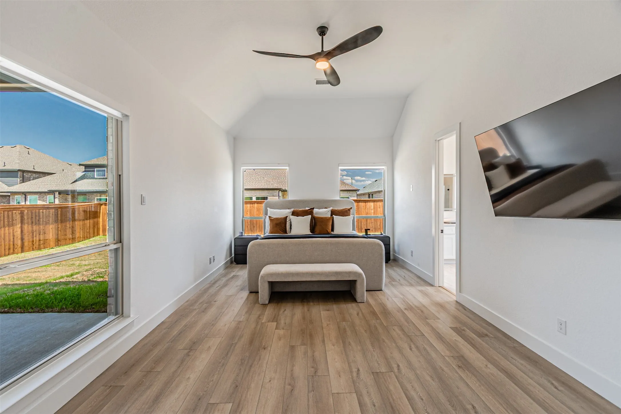 Vaulted ceiling with an attached ceiling fan, wood-finish flooring, and recessed lighting