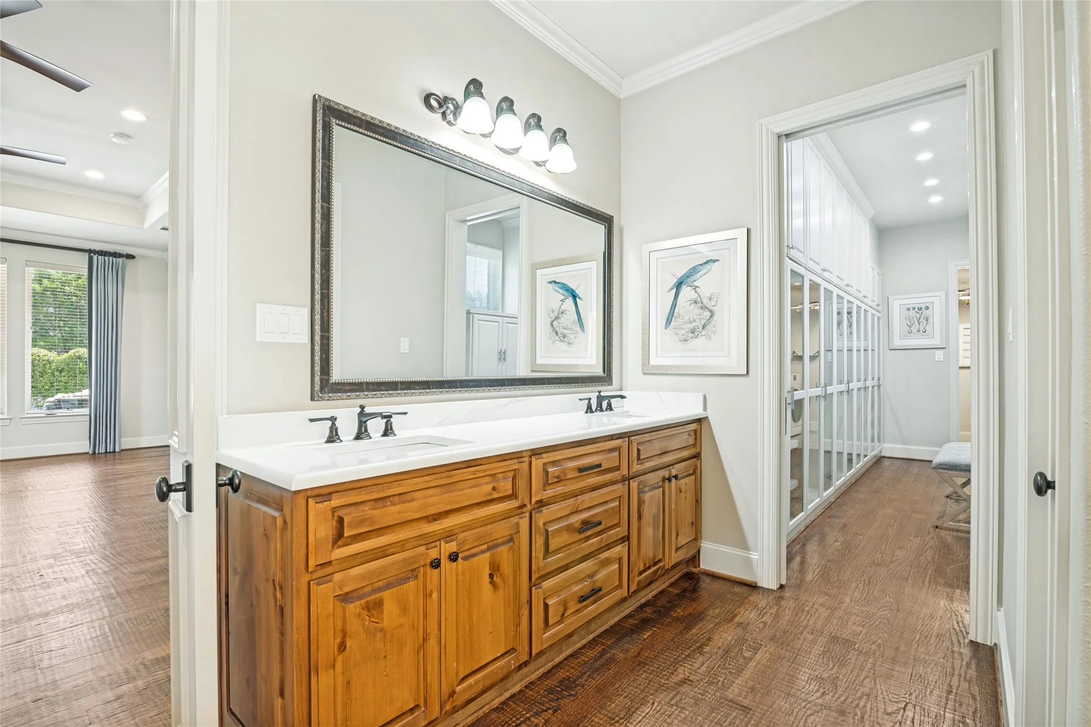 Dual undermount sinks set in a white countertop with wood-finish cabinetry