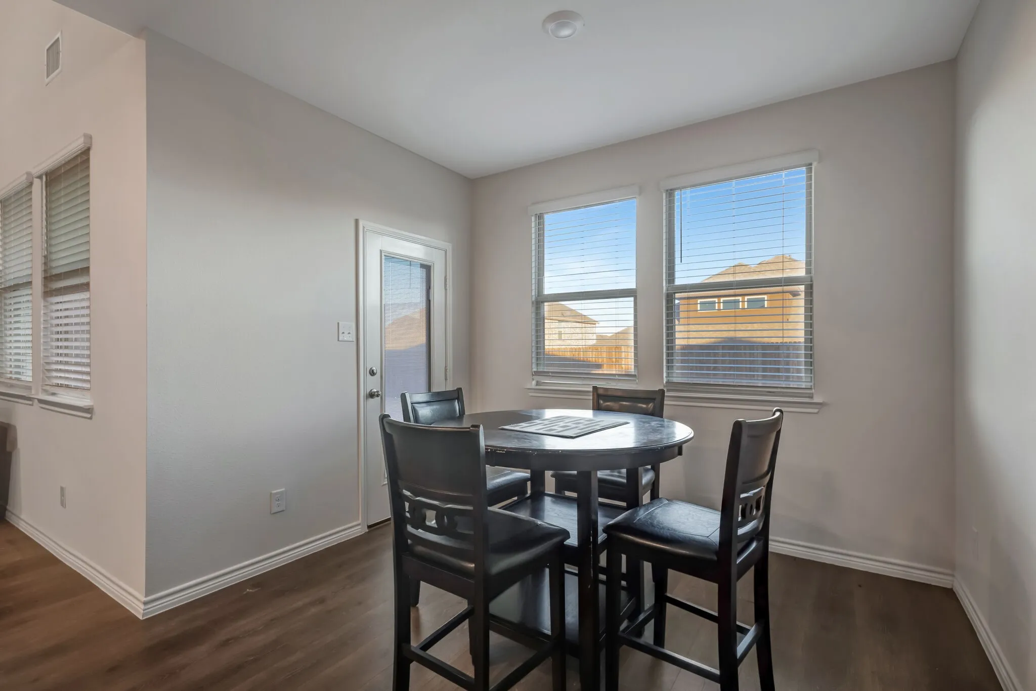 Wood-finish flooring, white trim, and light-toned walls