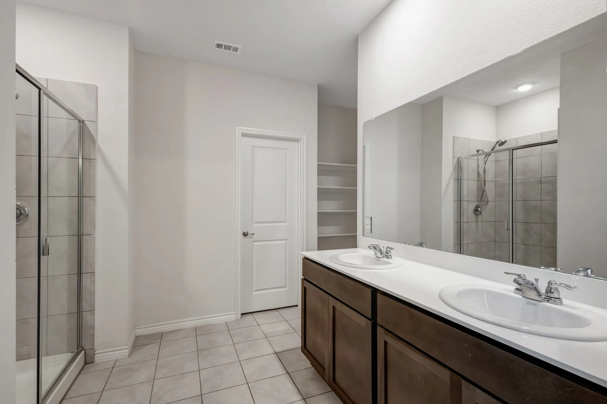 Dual vanity with white undermount sinks, white countertop, and dark wood-finish cabinetry