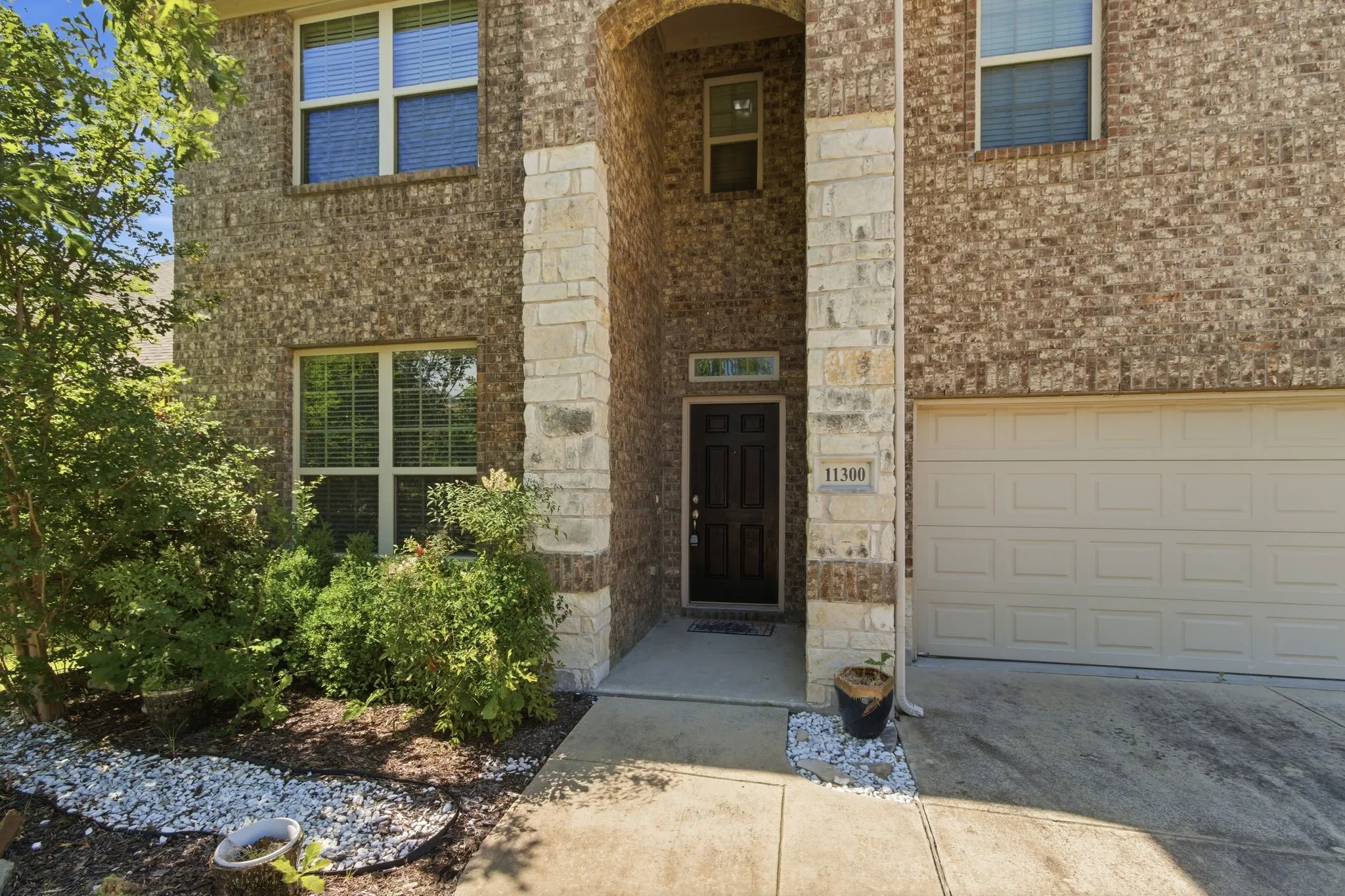Brick and stone exterior with a two-car garage