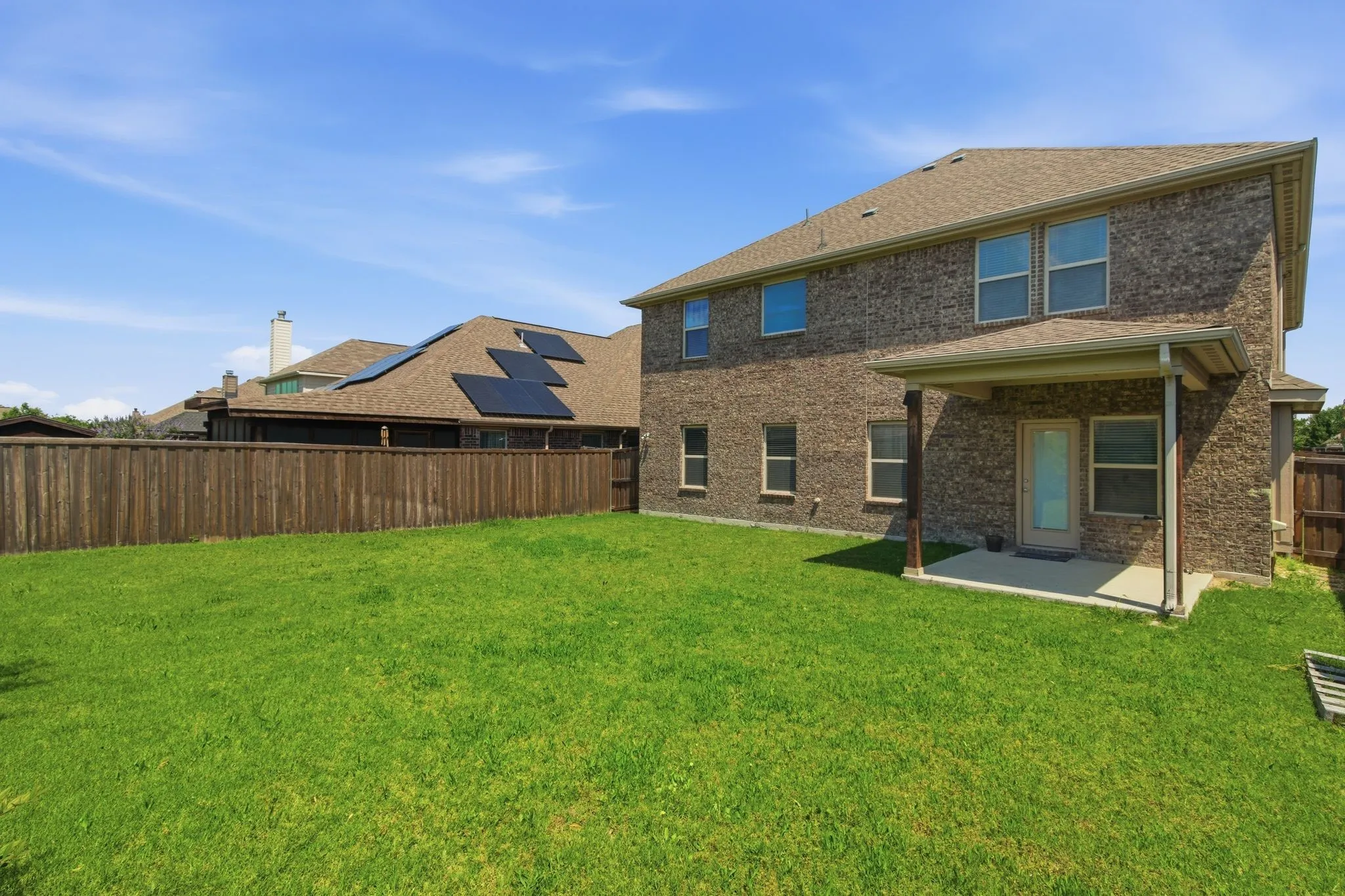 Expansive lawn area with a privacy fence