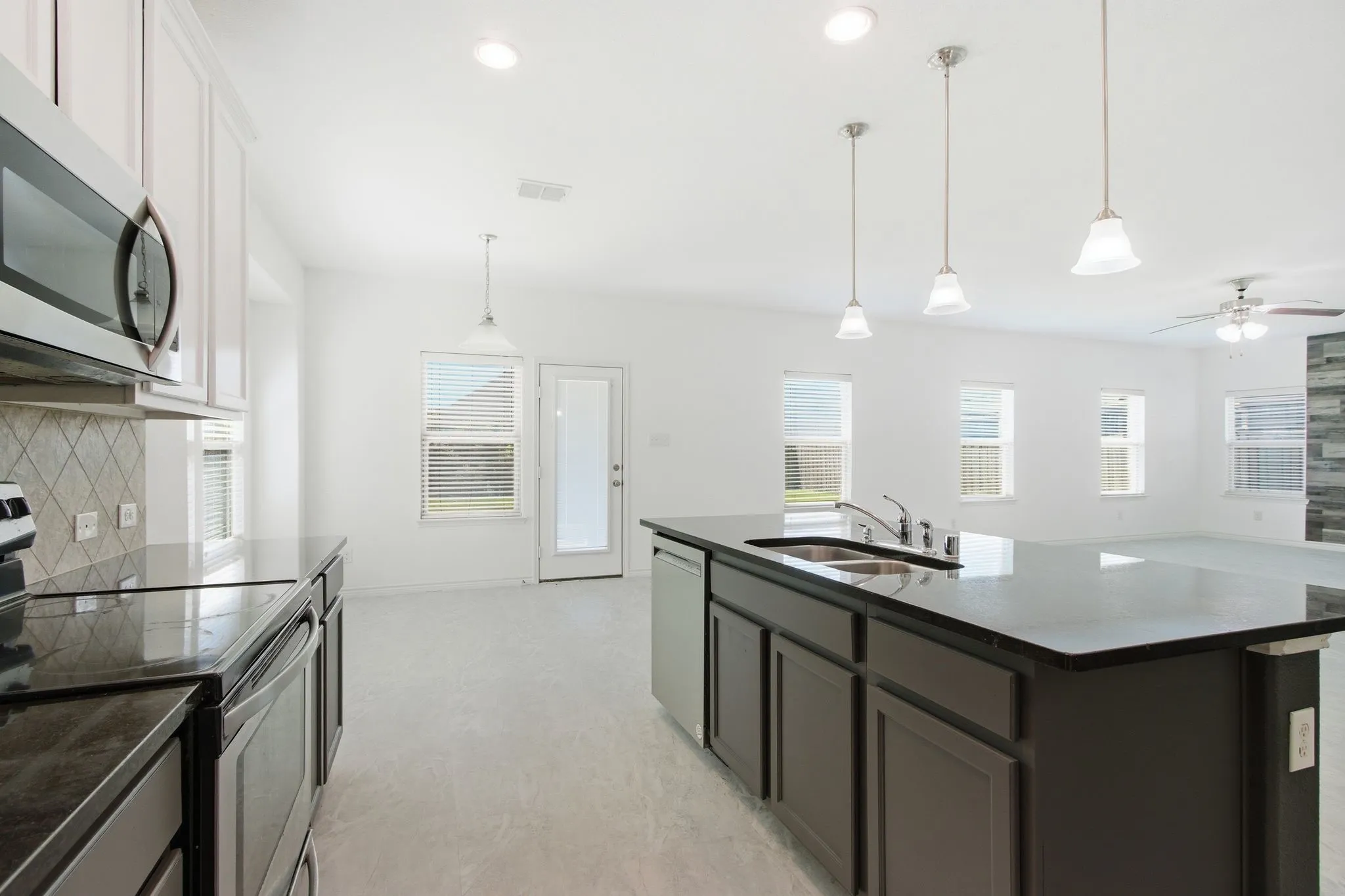 Kitchen with dark countertops, white upper cabinetry, and stainless steel appliances