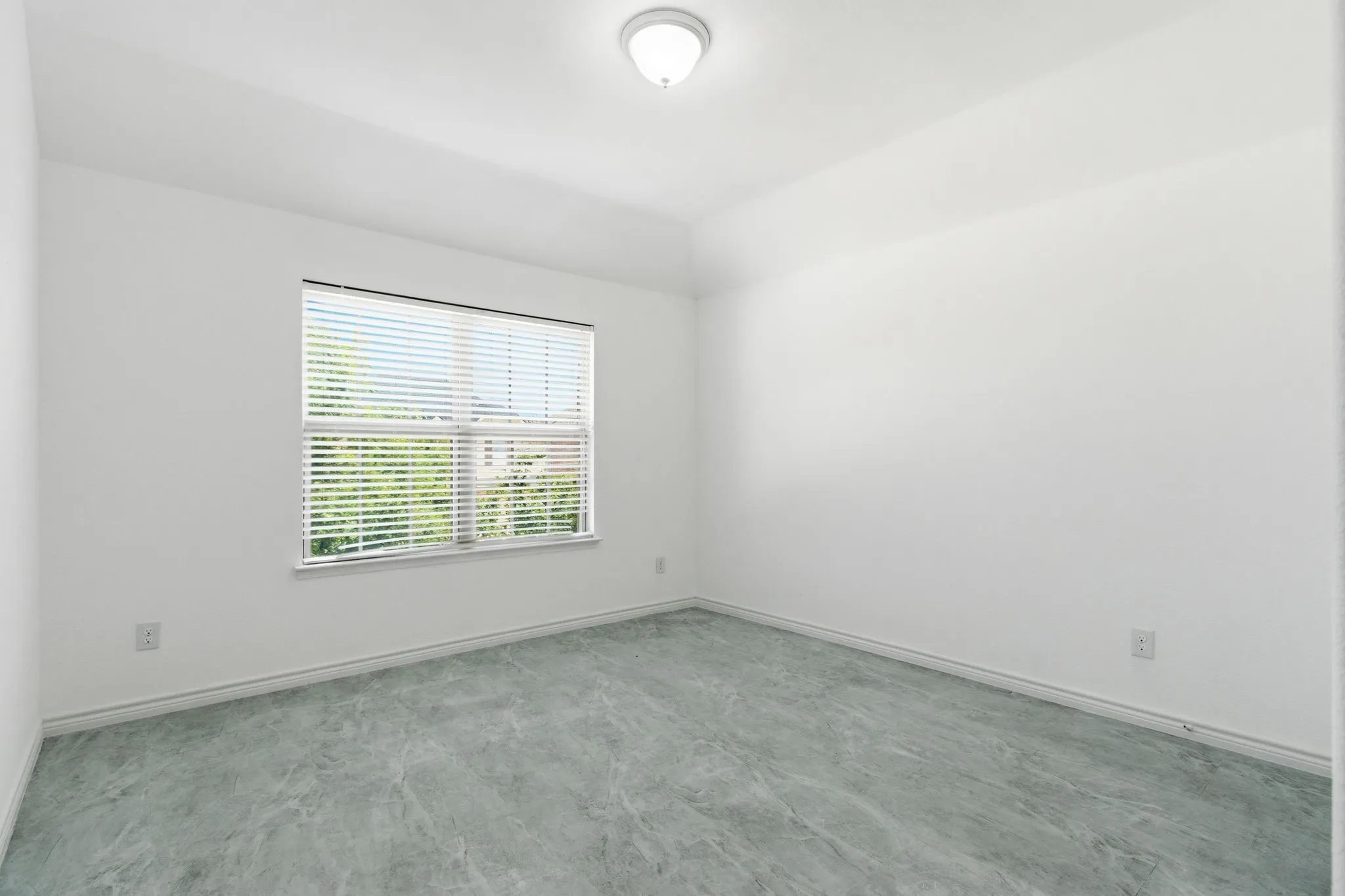 Neutral wall color with a contrasting flooring, window with horizontal blinds, and a flush mount ceiling light fixture