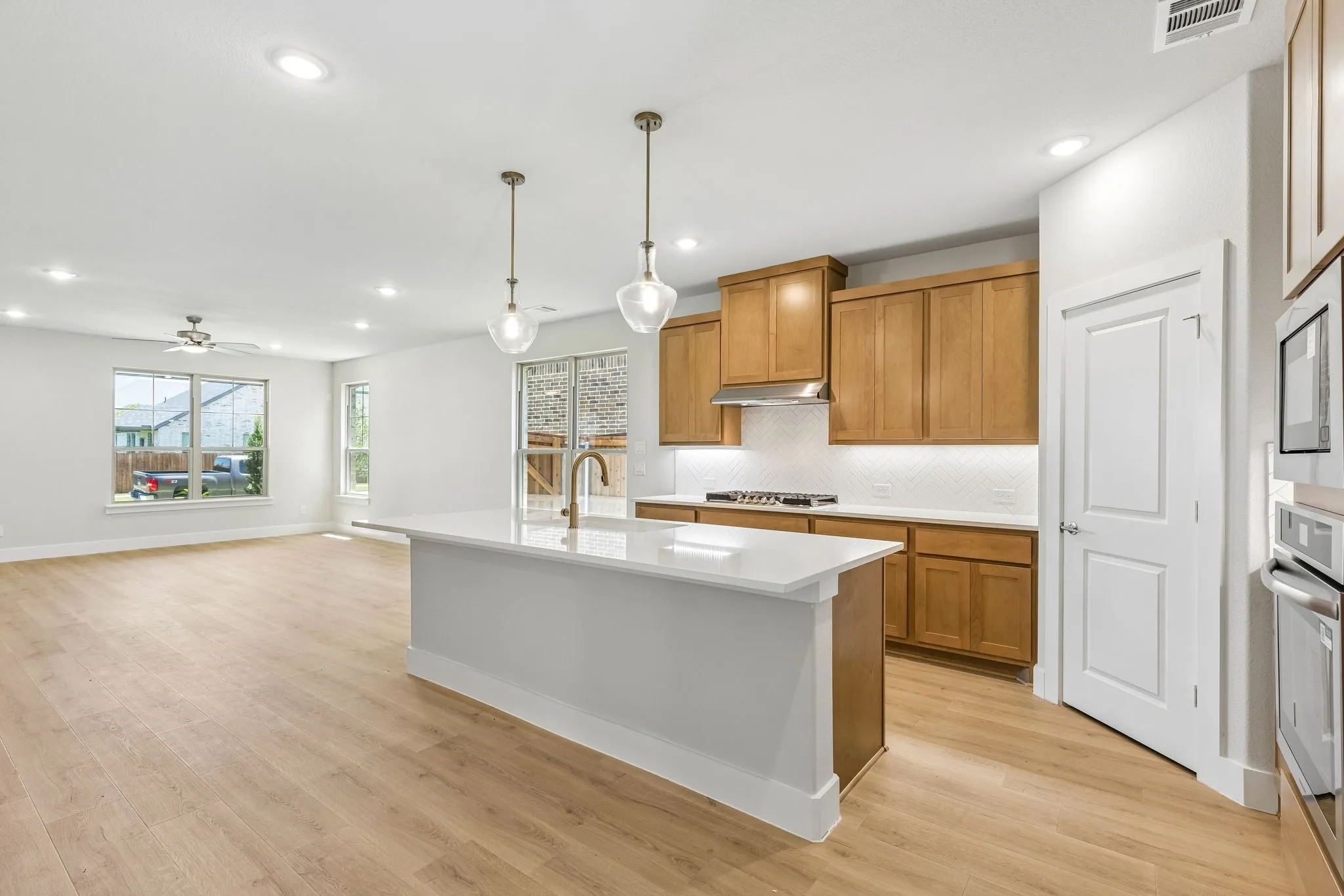 Open-concept living space featuring wood-finish flooring, recessed lighting, and a ceiling fan