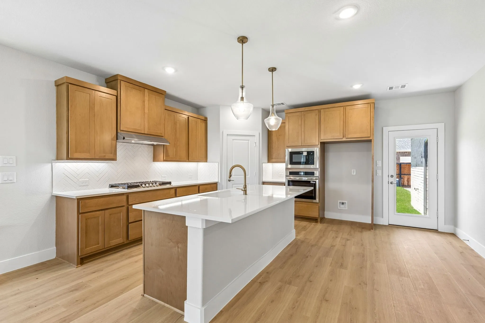 Kitchen featuring wood-finish flooring, recessed lighting, and a center island with pendant lights
