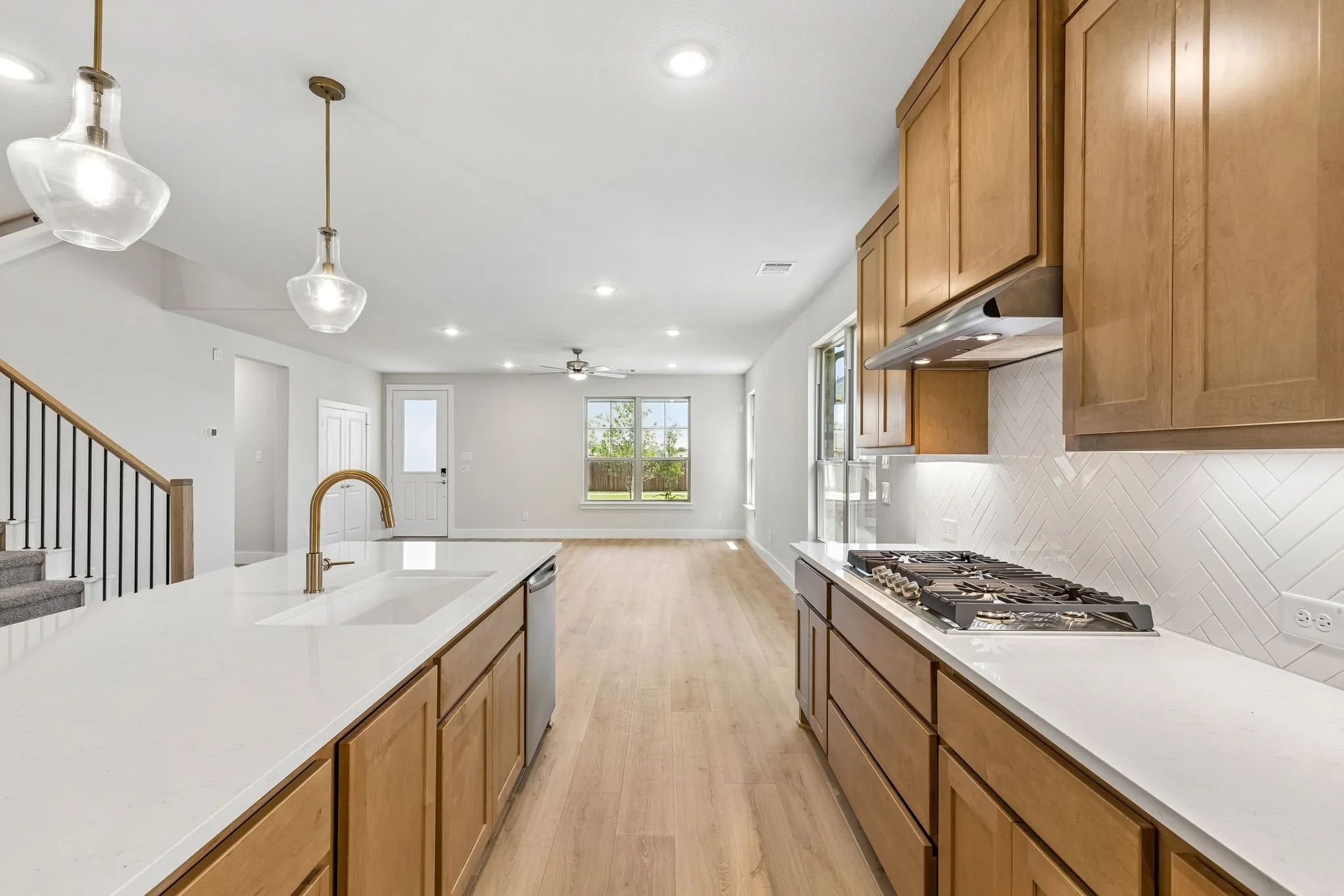 Kitchen with wood-finish cabinetry, white countertops, and a gas cooktop
