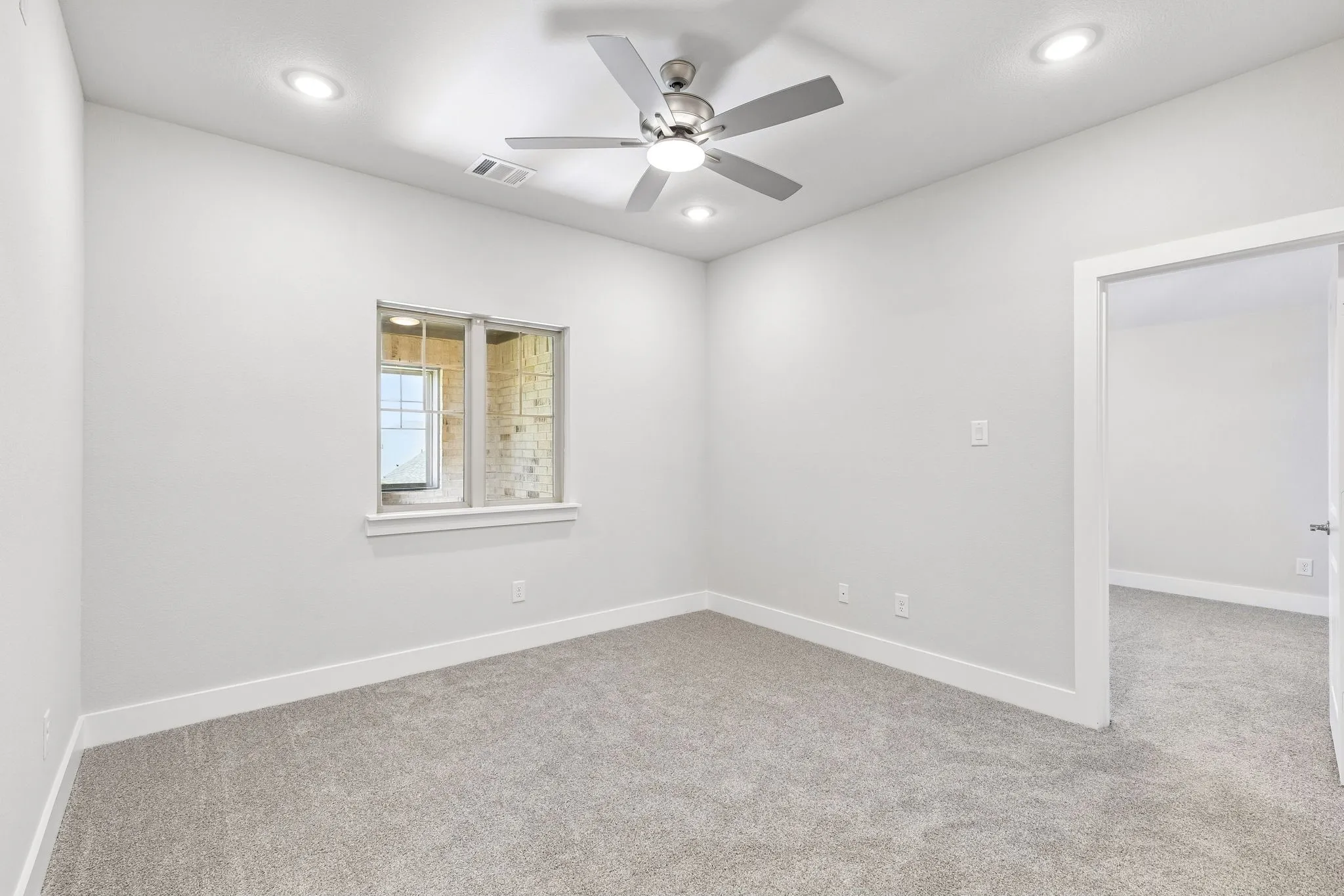 Recessed lighting, ceiling fan, neutral wall paint, gray carpet flooring, and a window with white trim