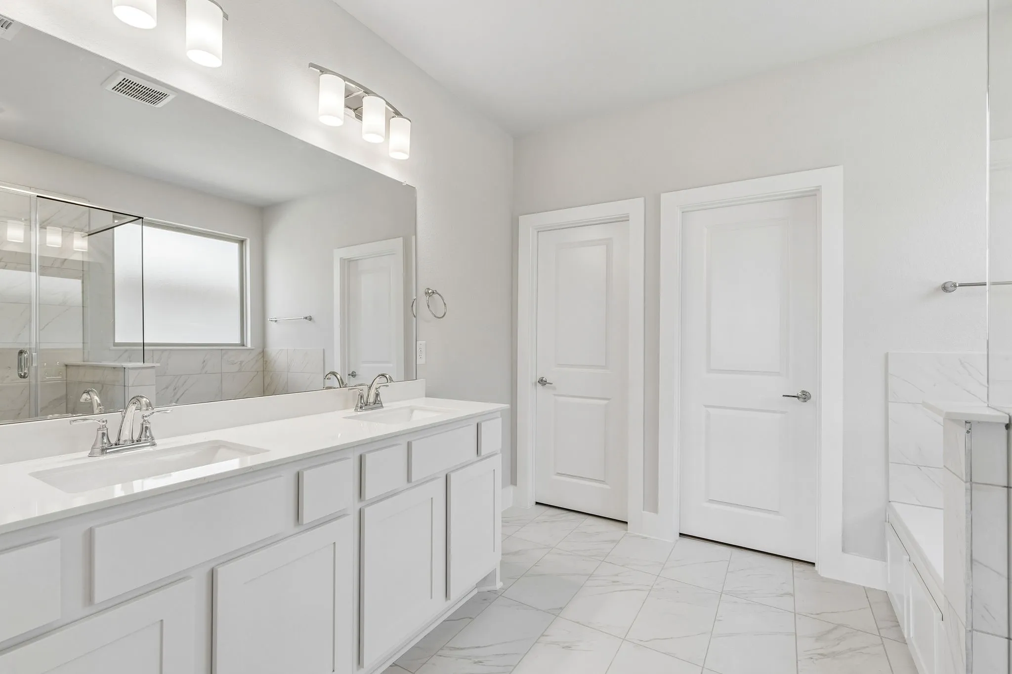Double vanity with undermount sinks, stone countertops, and ample storage